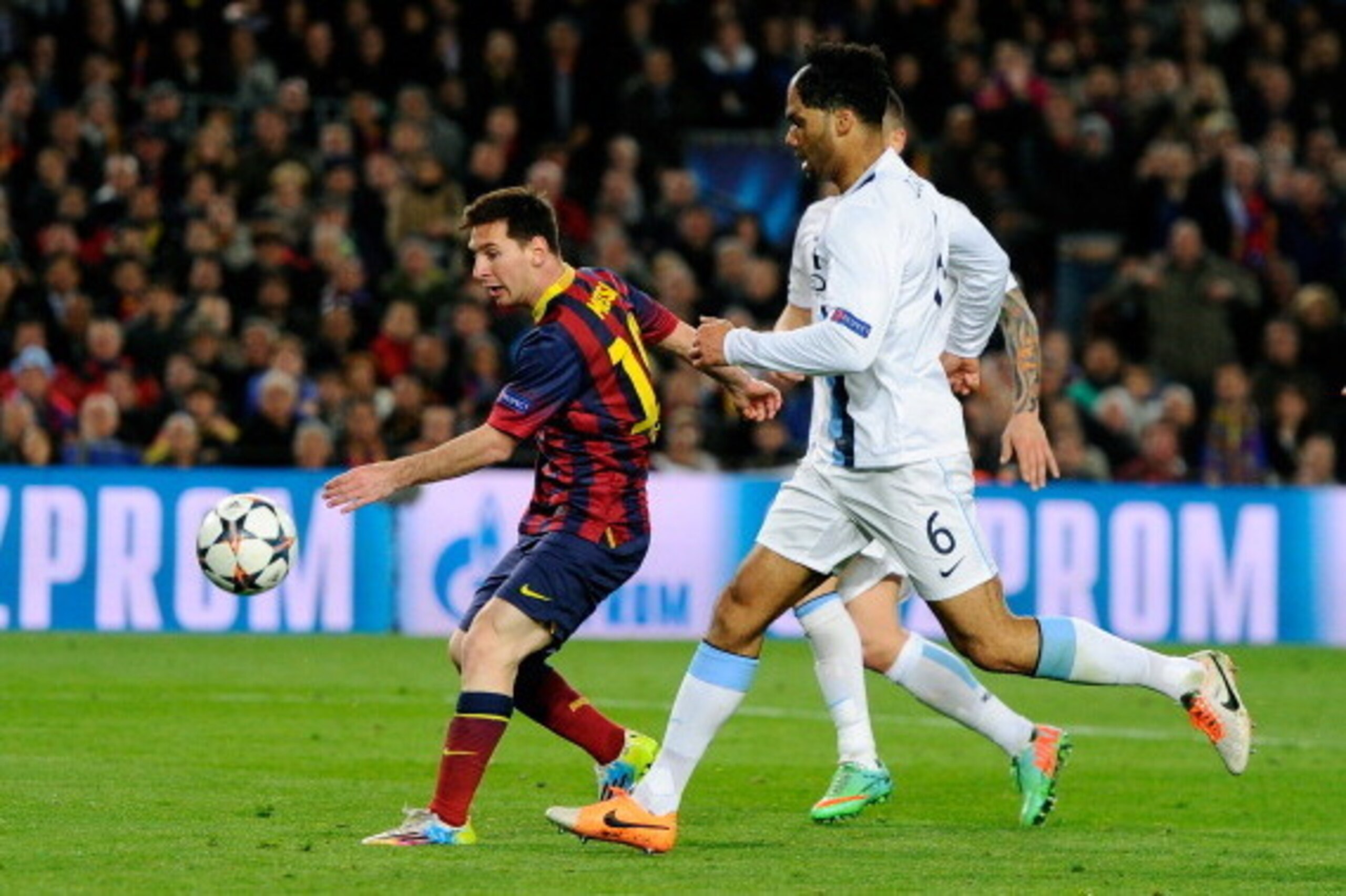 BARCELONA, SPAIN - MARCH 12:  Lionel Messi of Barcelona scores the opening goal as Joleon Lescott of Manchester City closes in during the UEFA Champions League Round of 16, second leg match between FC Barcelona and Manchester City  at Camp Nou on March 12