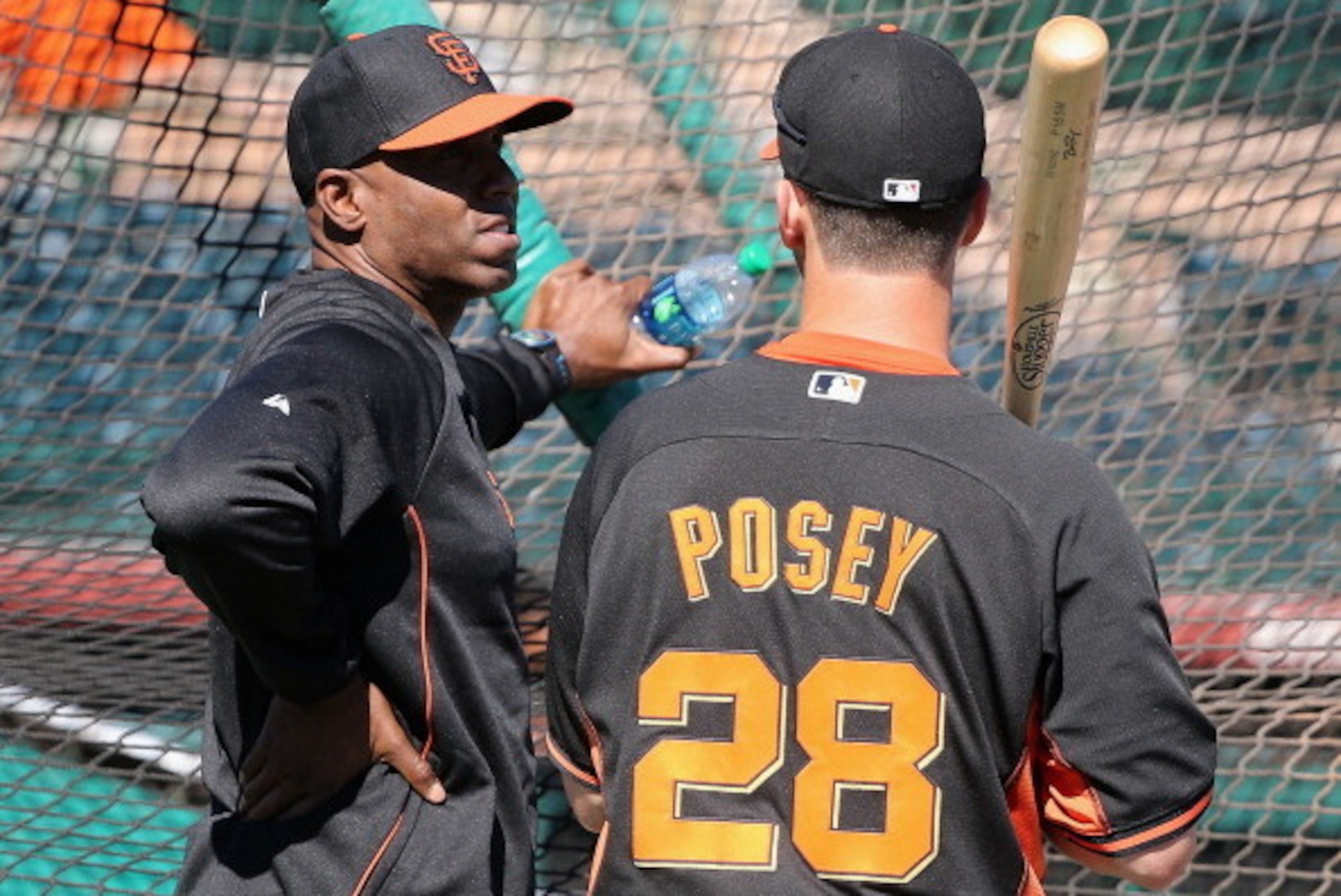 SCOTTSDALE, AZ - MARCH 10:  Barry Bonds (L) of the San Francisco Giants speaks with Buster Posey #28 as a special hitting coach for one week of Spring Training during batting practice at Scottsdale Stadium on March 10, 2014 in Scottsdale, Arizona.  (Photo