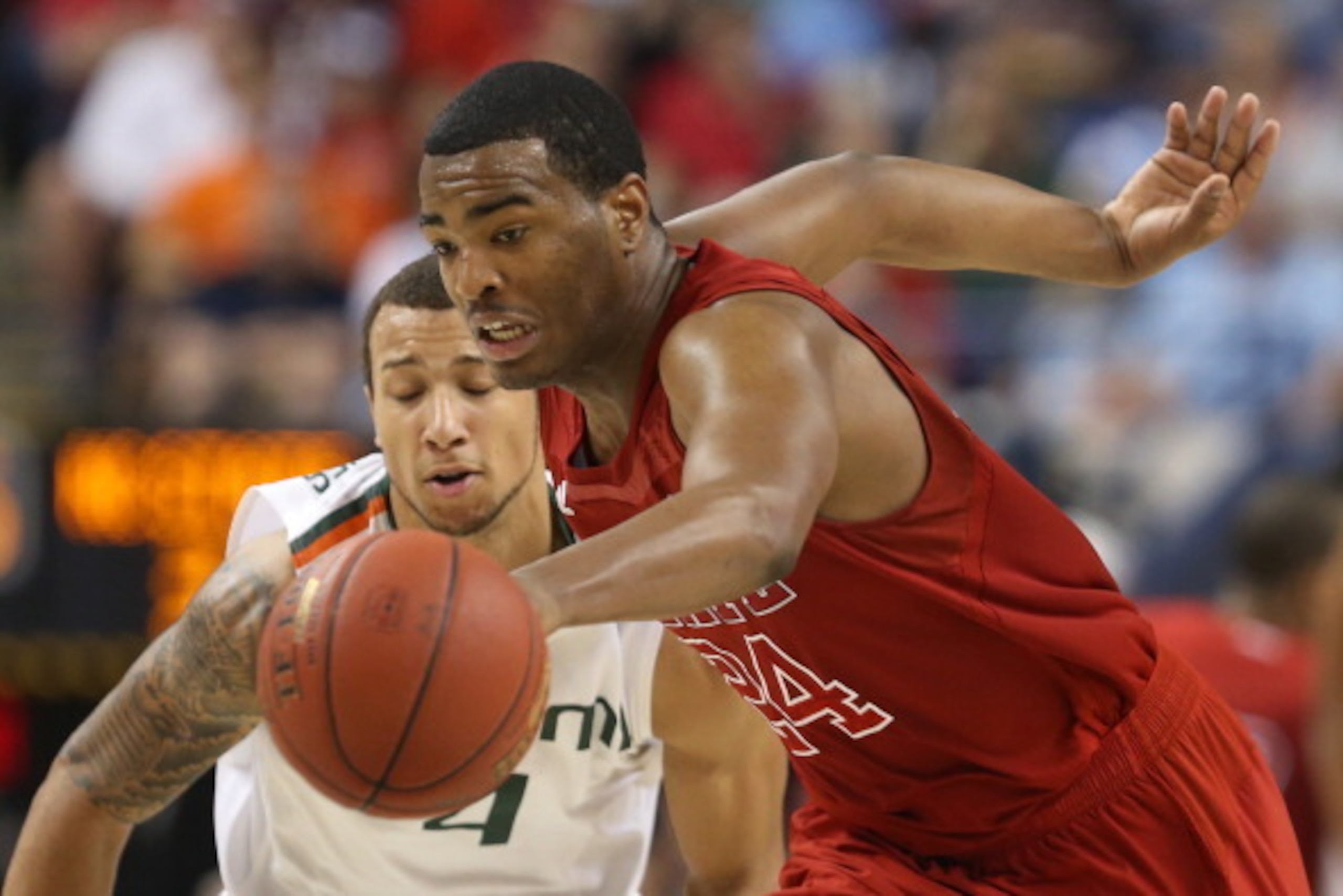 GREENSBORO, NC - MARCH 16:  T.J. Warren #24 of the North Carolina State Wolfpack moves the ball in front of Trey McKinney Jones #4 of the Miami Hurricanes in the second half during the men's ACC Tournament semifinals at Greensboro Coliseum on March 16, 20