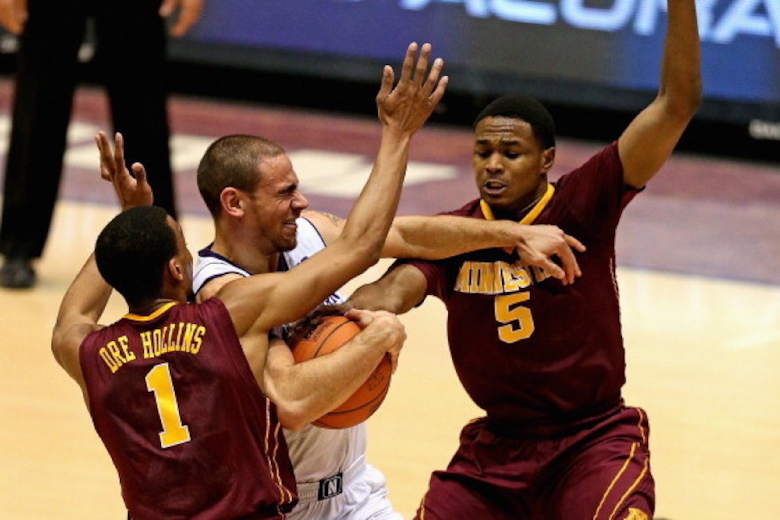 EVANSTON, IL - FEBRUARY 16:  Tre Demps #14 of the Northwestern Wildcats tries to drive between Andre Hollins #1 and Daquein McNeil #5 of the Minnesota Golden Gophers at Welsh-Ryan Arena on February 16, 2014 in Evanston, Illinois.  (Photo by Jonathan Danie