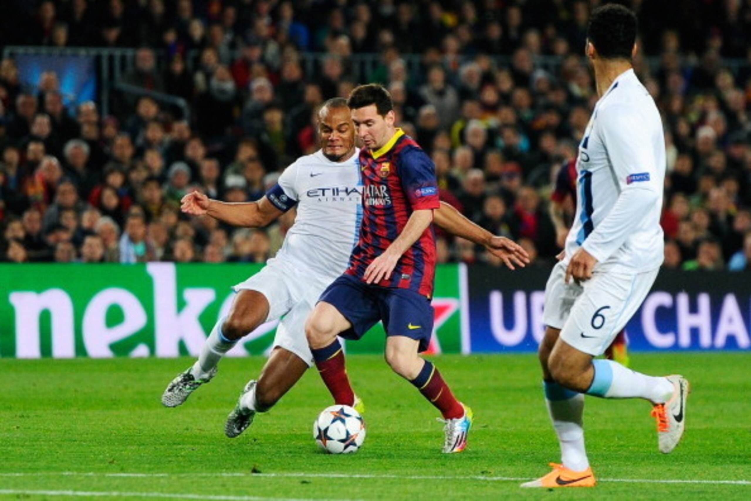 BARCELONA, SPAIN - MARCH 12:  Lionel Messi of Barcelona is tackled by Vincent Kompany of Manchester City during the UEFA Champions League Round of 16, second leg match between FC Barcelona and Manchester City  at Camp Nou on March 12, 2014 in Barcelona, S