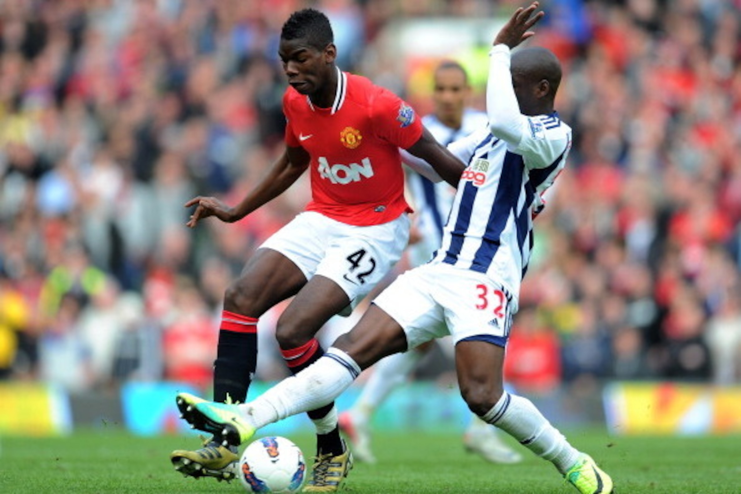 MANCHESTER, ENGLAND - MARCH 11:  Paul Pogba of Manchester United is challenged by Marc-Antoine Fortune of West Bromwich Albionduring the Barclays Premier League match between Manchester United and West Bromwich Albion at Old Trafford on March 11, 2012 in