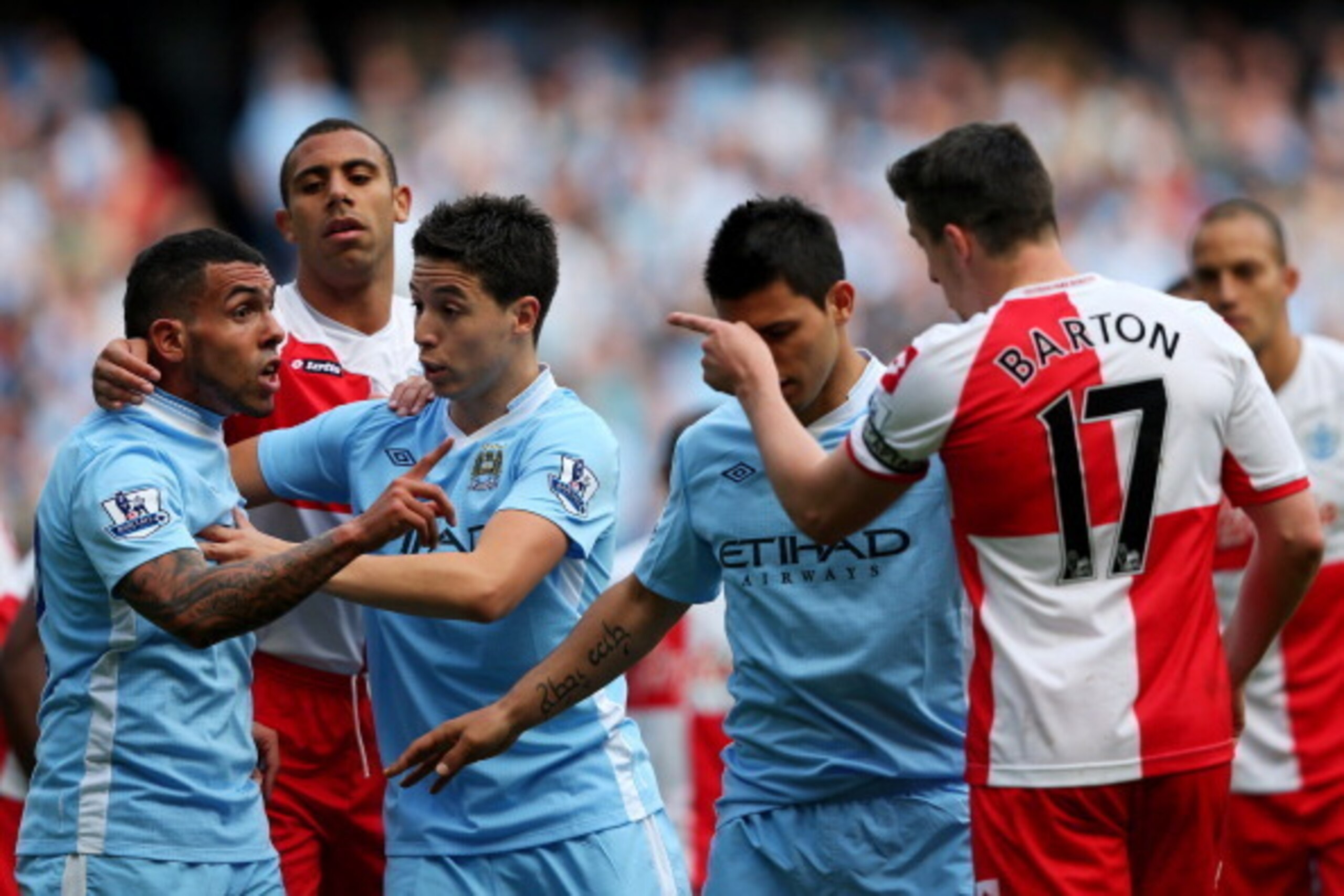 MANCHESTER, ENGLAND - MAY 13:  Carlos Tevez of Manchester City clashes with Joey Barton of QPR after being fouled during the Barclays Premier League match between Manchester City and Queens Park Rangers at the Etihad Stadium on May 13, 2012 in Manchester,