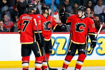 CALGARY, AB - MARCH 12: Mark Giordano #5, Sean Monahan #23 and TJ Brodie #7 of the Calgary Flames celebrate a goal against the Anaheim Ducks at Scotiabank Saddledome on March 12, 2014 in Calgary, Alberta, Canada. (Photo by Gerry Thomas/NHLI via Getty Imag
