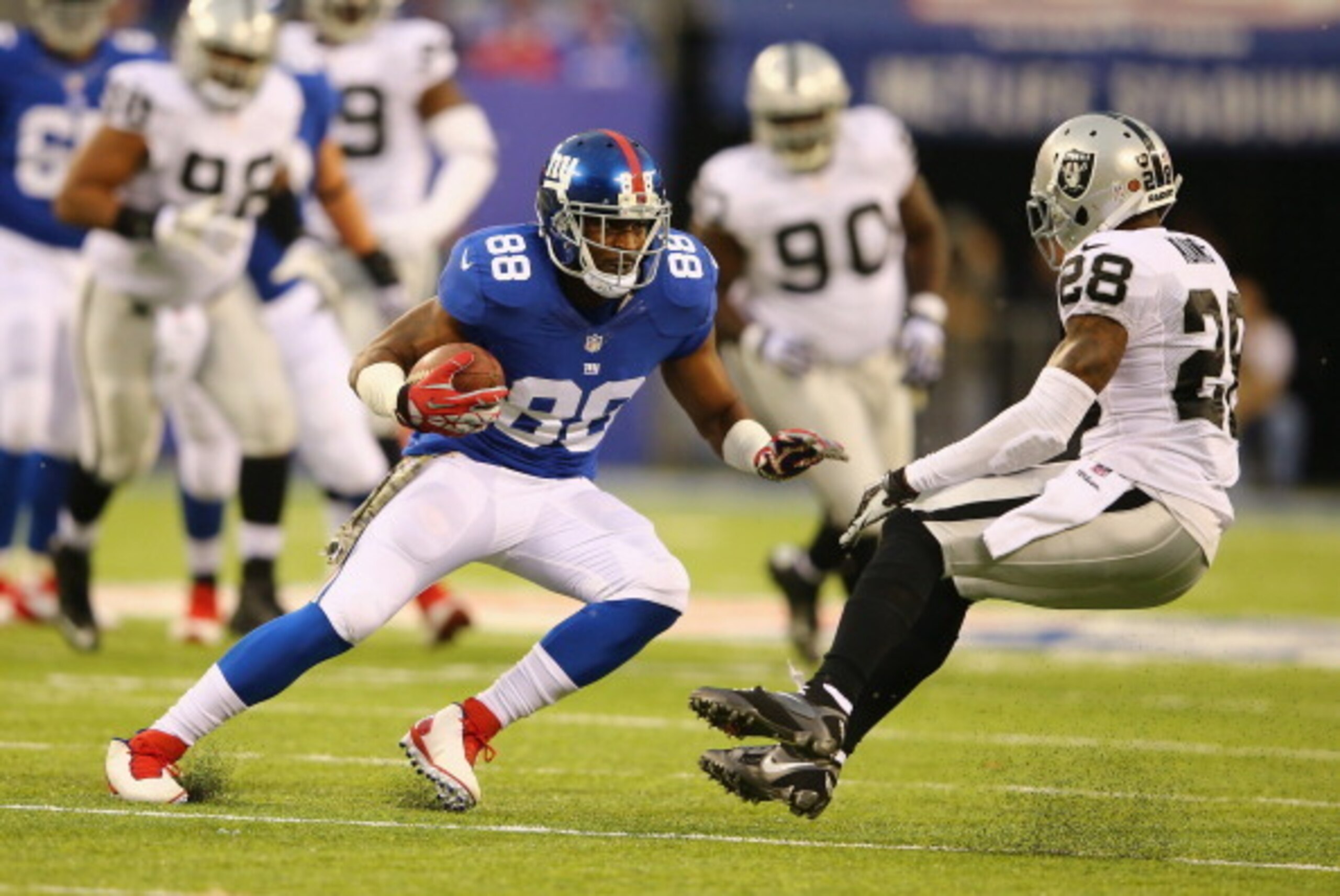 EAST RUTHERFORD, NJ - NOVEMBER 10:   Hakeem Nicks #88 of the New York Giants runs after a catch against  Phillip Adams #28 of the Oakland Raiders during their game at MetLife Stadium on November 10, 2013 in East Rutherford, New Jersey.  (Photo by Al Bello