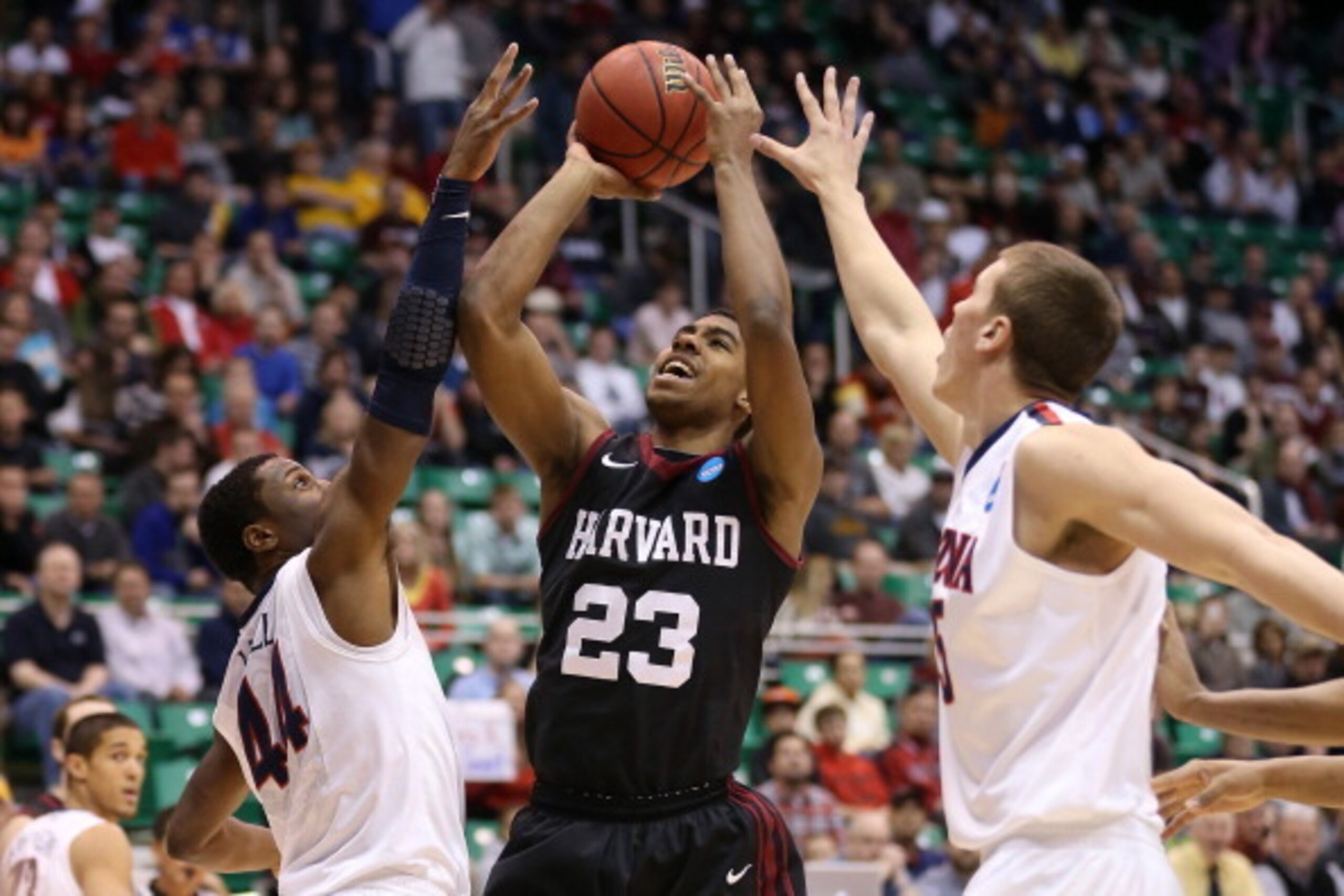 SALT LAKE CITY, UT - MARCH 23:  Wesley Saunders #23 of the Harvard Crimson goes up for a shot between Solomon Hill #44 and Kaleb Tarczewski #35 of the Arizona Wildcats in the first half during the third round of the 2013 NCAA Men's Basketball Tournament a
