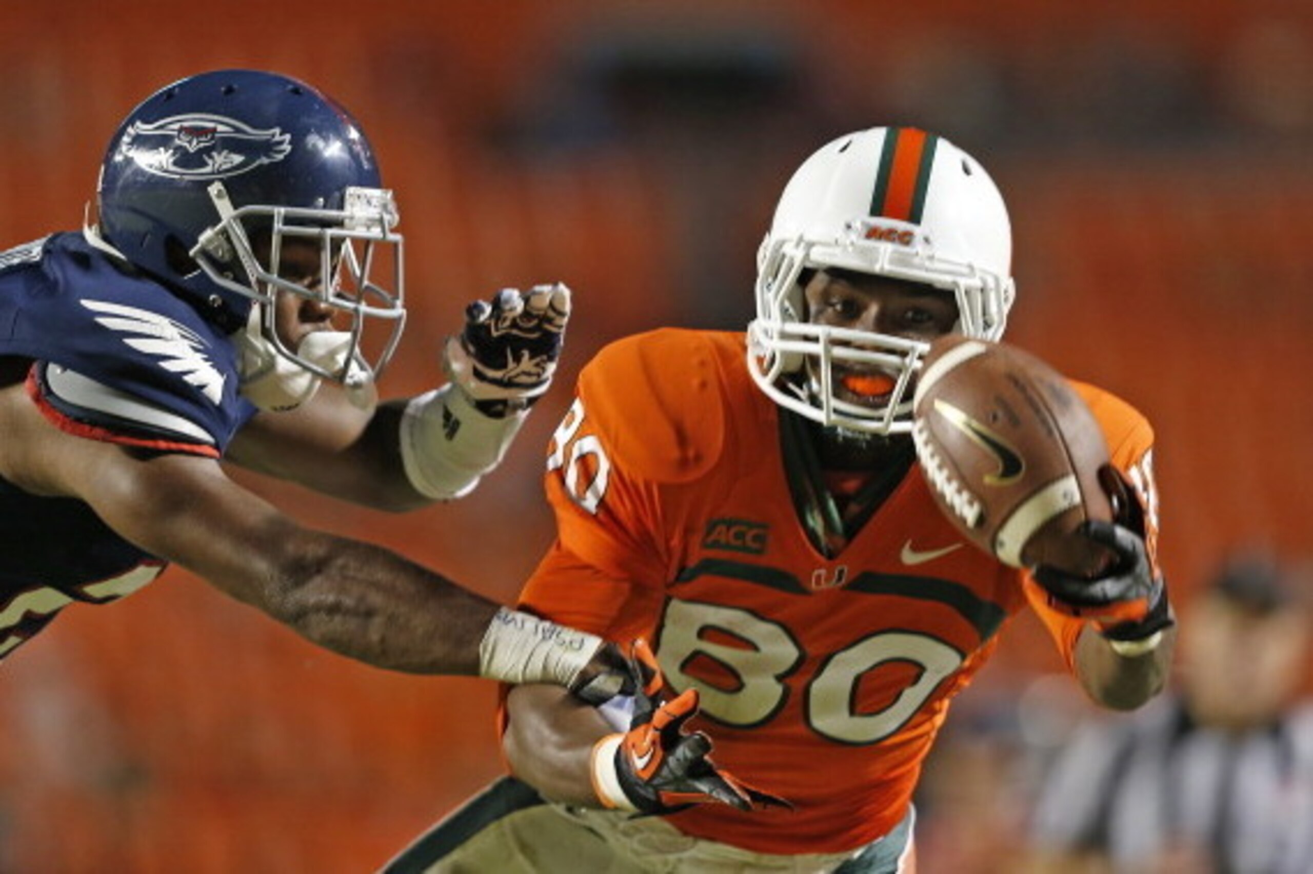 MIAMI GARDENS, FL - AUGUST 30: Rashawn Scott #80 of the Miami Hurricanes catches the ball on the one yard line while being defended by D'Joun Smith #21 of the Florida Atlantic Owls on August 30, 2013 at Sun Life Stadium in Miami Gardens, Florida. Miami de