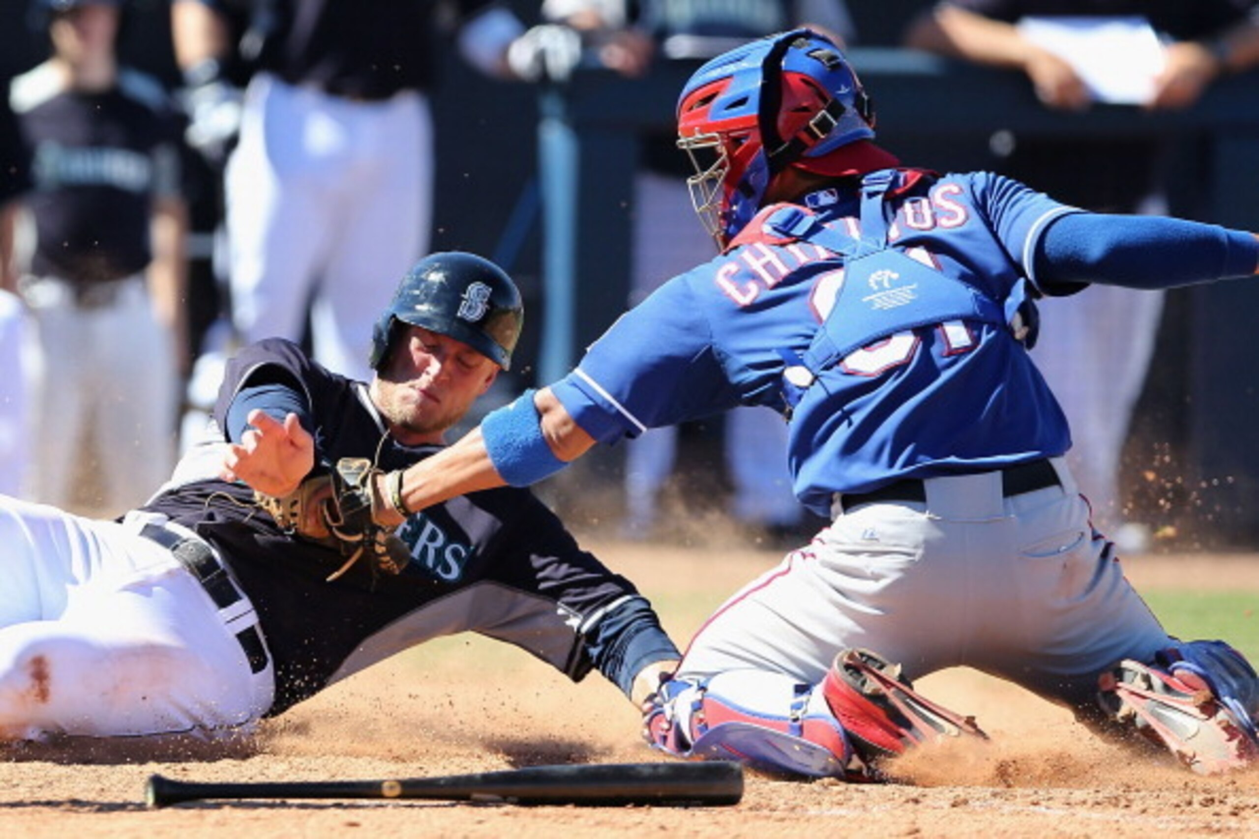 PEORIA, AZ - MARCH 09:  Brad Miller #5 of the Seattle Mariners is tagged out at home plate by catcher Robinson Chirinos #61 of the Texas Rangers during the fifth inning of the spring training game at Peoria Stadium on March 9, 2014 in Peoria, Arizona.  (P