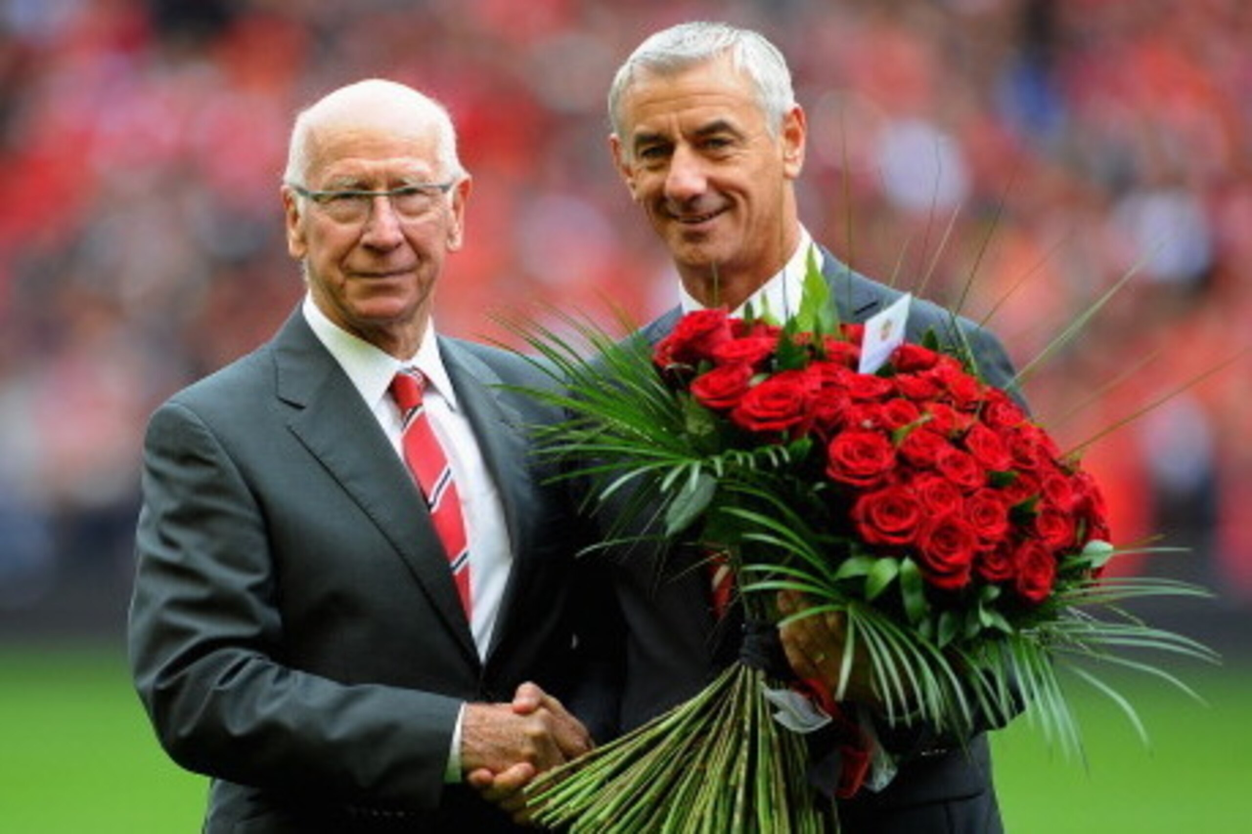 LIVERPOOL, ENGLAND - SEPTEMBER 23: Sir Bobby Charlton presents Ian Rush with flowers before the Barclays Premier League match between Liverpool and Manchester United at Anfield on September 23, 2012 in Liverpool, England.  (Photo by Michael Regan/Getty Im