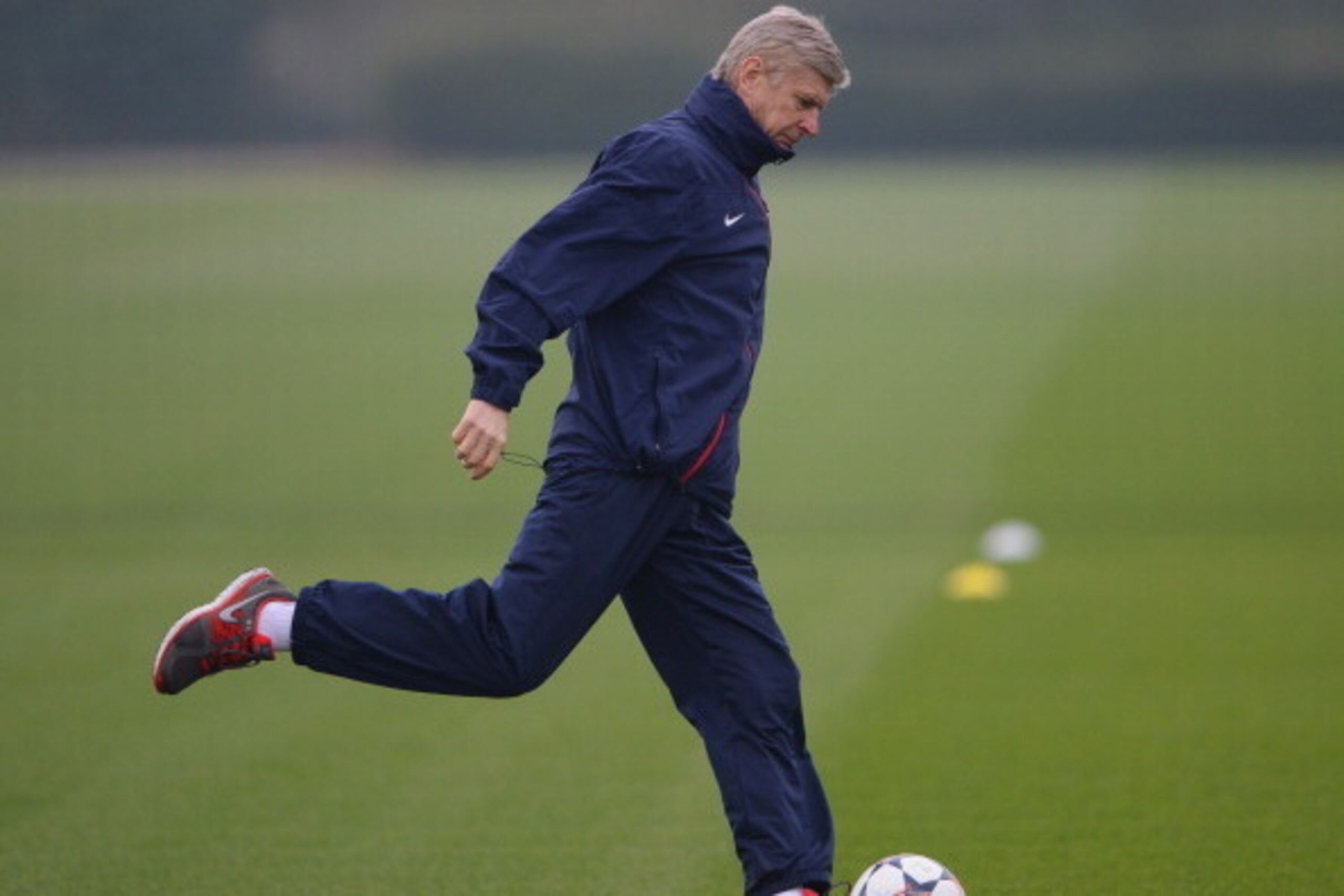 ST ALBANS, ENGLAND - MARCH 10:  Arsenal manager Arsene Wenger kicks a ball during the Arsenal training session at London Colney on March 10, 2014 in St Albans, England.  (Photo by Michael Regan/Getty Images)