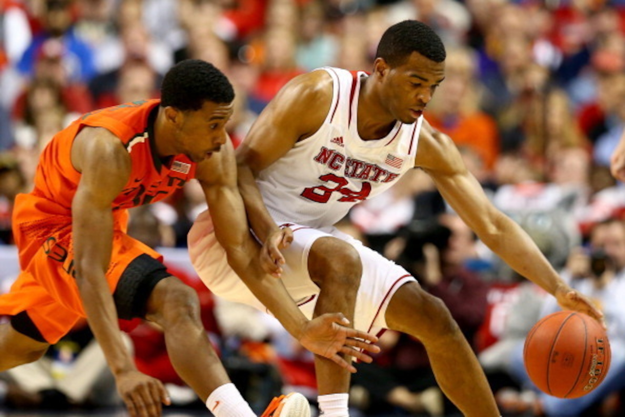 GREENSBORO, NC - MARCH 13: Garrius Adams #25 of the Miami Hurricanes goes after a loose ball against T.J. Warren #24 of the North Carolina State Wolfpack during the second round of the 2014 Men's ACC Basketball Tournament at Greensboro Coliseum on March GREENSBORO, NC - MARCH 13: Garrius Adams #25 of the Miami Hurricanes goes after a loose ball against T.J. Warren #24 of the North Carolina State Wolfpack during the second round of the 2014 Men's ACC Basketball Tournament at Greensboro Coliseum on March