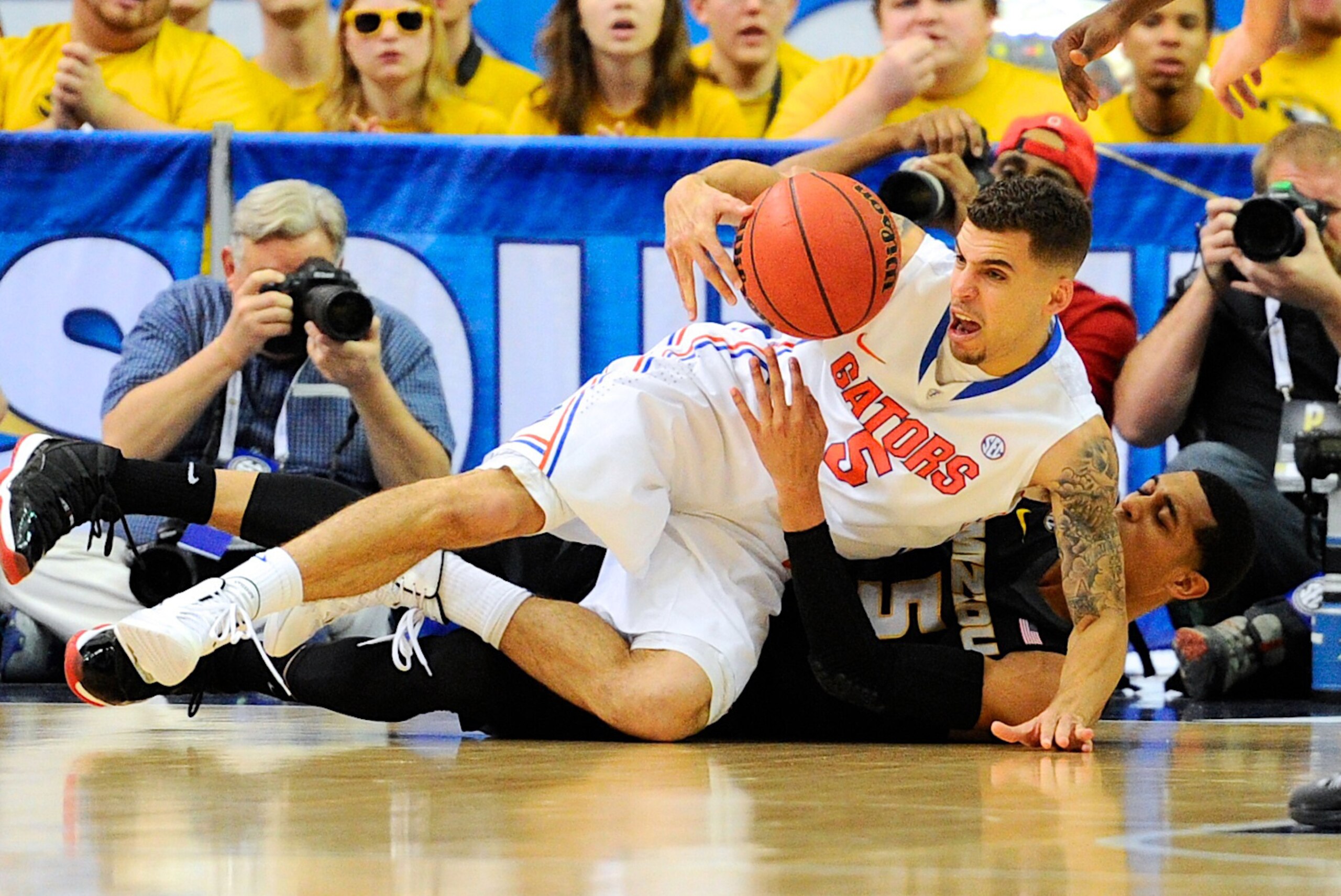 Mar 14, 2014; Atlanta, GA, USA; Florida Gators guard Scottie Wilbekin (5) and Missouri Tigers guard Jordan Clarkson (5) battle for the ball on the floor during the second half in the quarterfinals of the SEC college basketball tournament at Georgia Dome.