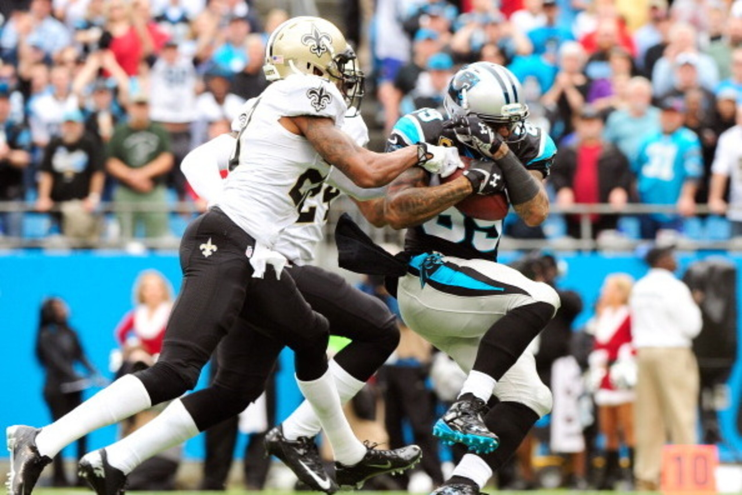CHARLOTTE, NC - DECEMBER 22:  Steve Smith #89 of the Carolina Panthers makes a catch as Corey White #24 and Keenan Lewis #28 of the New Orleans Saints defend during their game at Bank of America Stadium on December 22, 2013 in Charlotte, North Carolina.  