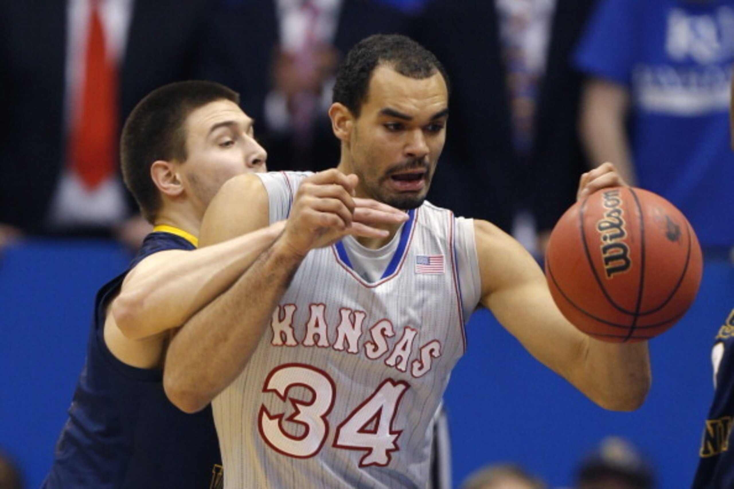 LAWRENCE, KS - FEBRUARY 8:  Perry Ellis #34 of the Kansas Jayhawks tries to grab a rebound but is fouled by Nathan Adrian #11 of the West Virginia Mountaineers in the second half at Allen Fieldhouse on February 8, 2014 in Lawrence, Kansas. (Photo by Ed Zu
