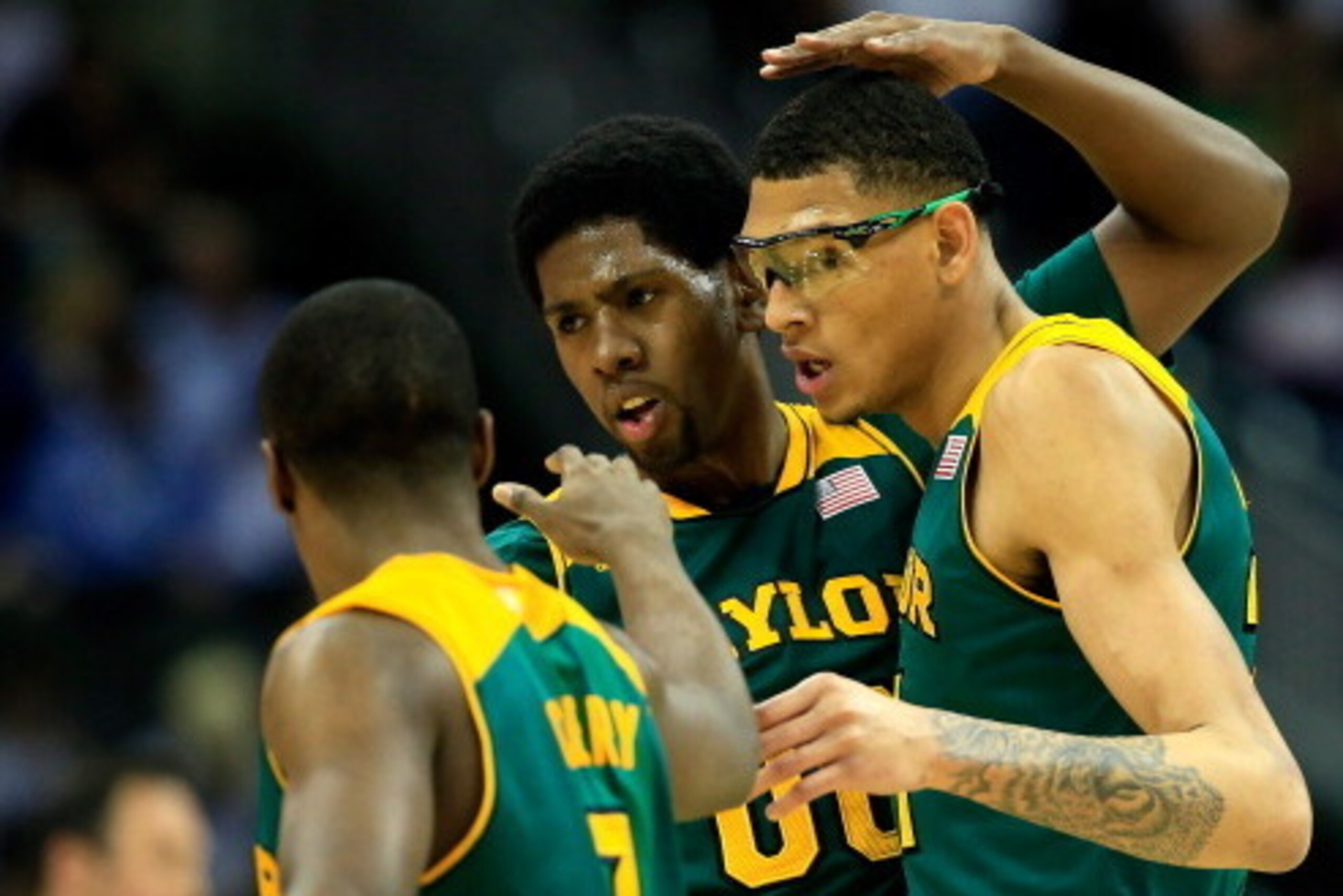 KANSAS CITY, MO - MARCH 14:  Royce O'Neale #00 of the Baylor Bears congratulates Isaiah Austin #21 and Kenny Chery #1 as they walk back to the bench during a timeout in the Big 12 Basketball Tournament semifinal game against the Texas Longhorns at Sprint 