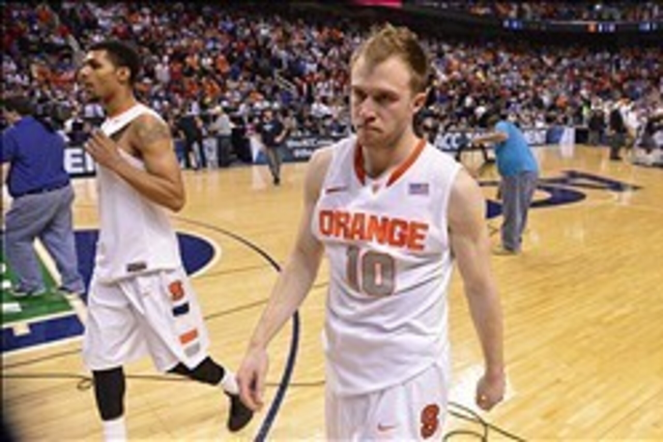 Mar 14, 2014; Greensboro, NC, USA;  Syracuse Orange guard Michael Gbinije (0) and guard Trevor Cooney (10) walk off the court. The Wolfpack defeated the Orange 66-63 in the quarterfinals of the ACC college basketball tournament at Greensboro Coliseum. Man