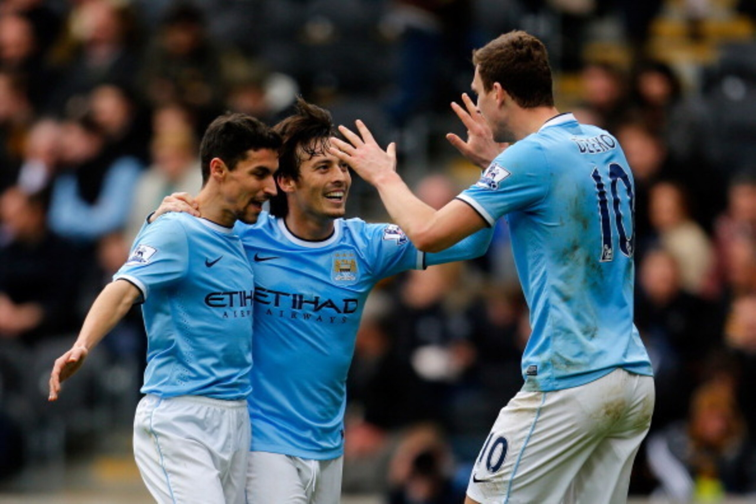 HULL, ENGLAND - MARCH 15: Edin Dzeko (R) of Manchester City celebrates his goal with team mates Jesus Navas (L) and David Silva during the Barclays Premier League match between Hull City and Manchester City at the KC Stadium on March 15, 2014 in Hull, Eng