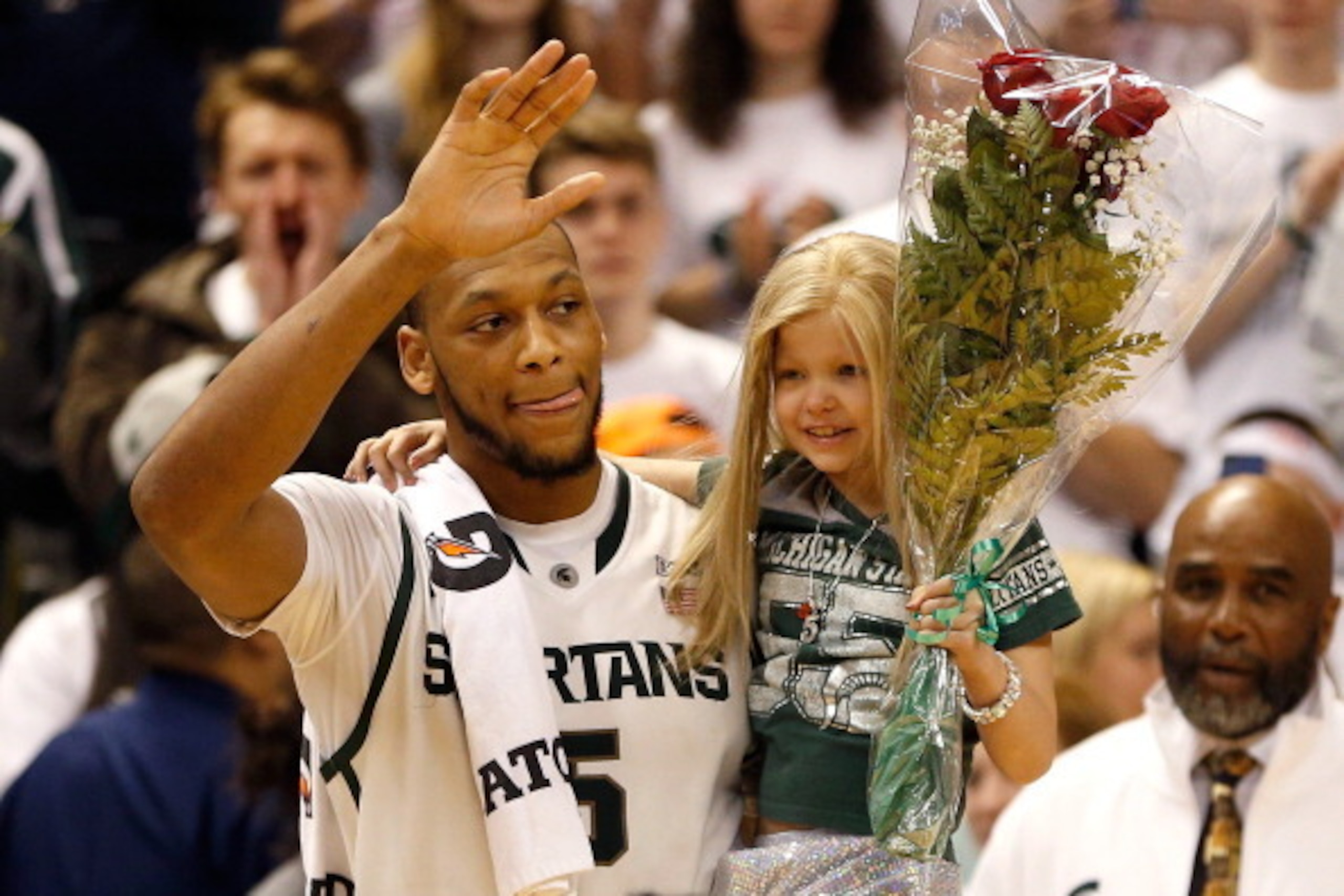 EAST LANSING, MI - FEBRUARY 06:  Adreian Payne #5 of the Michigan State Spartans walks on the floor for Senior night with Lacey Holsworth, a 8-year-old from St. Johns Michigan who is battling cancer, after defeating the Iowa Hawkeyes 86-76 at the Jack T. 