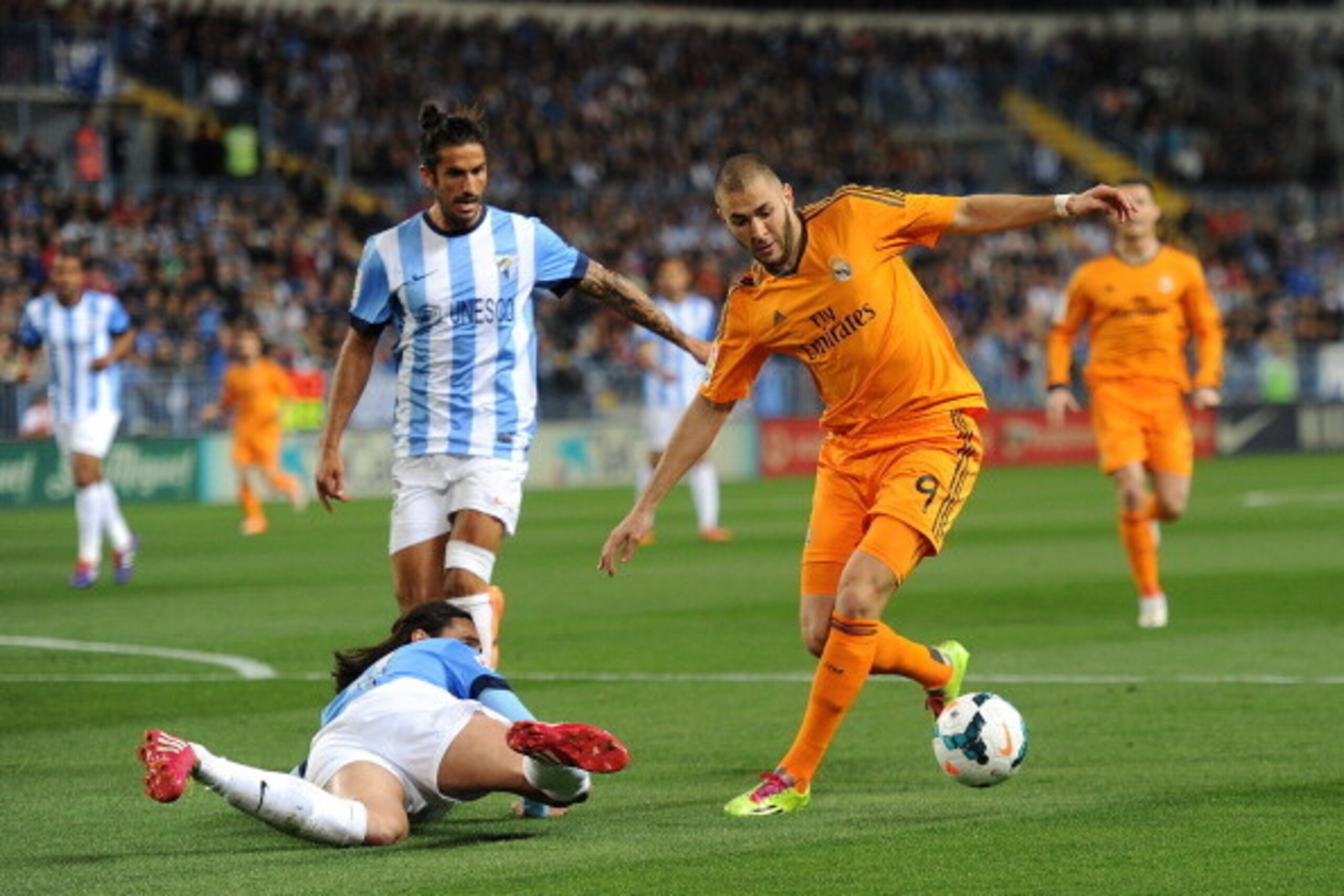 MALAGA, SPAIN - MARCH 15:  Karim Benzema (R) of Real Madrid FC gets past a fallen Sergio Sanchez of Malaga  during the La Liga match between Malaga and Real Madrid at La Rosaleda Stadium on March 15, 2014 in Malaga, Spain.  (Photo by Denis Doyle/Getty Ima