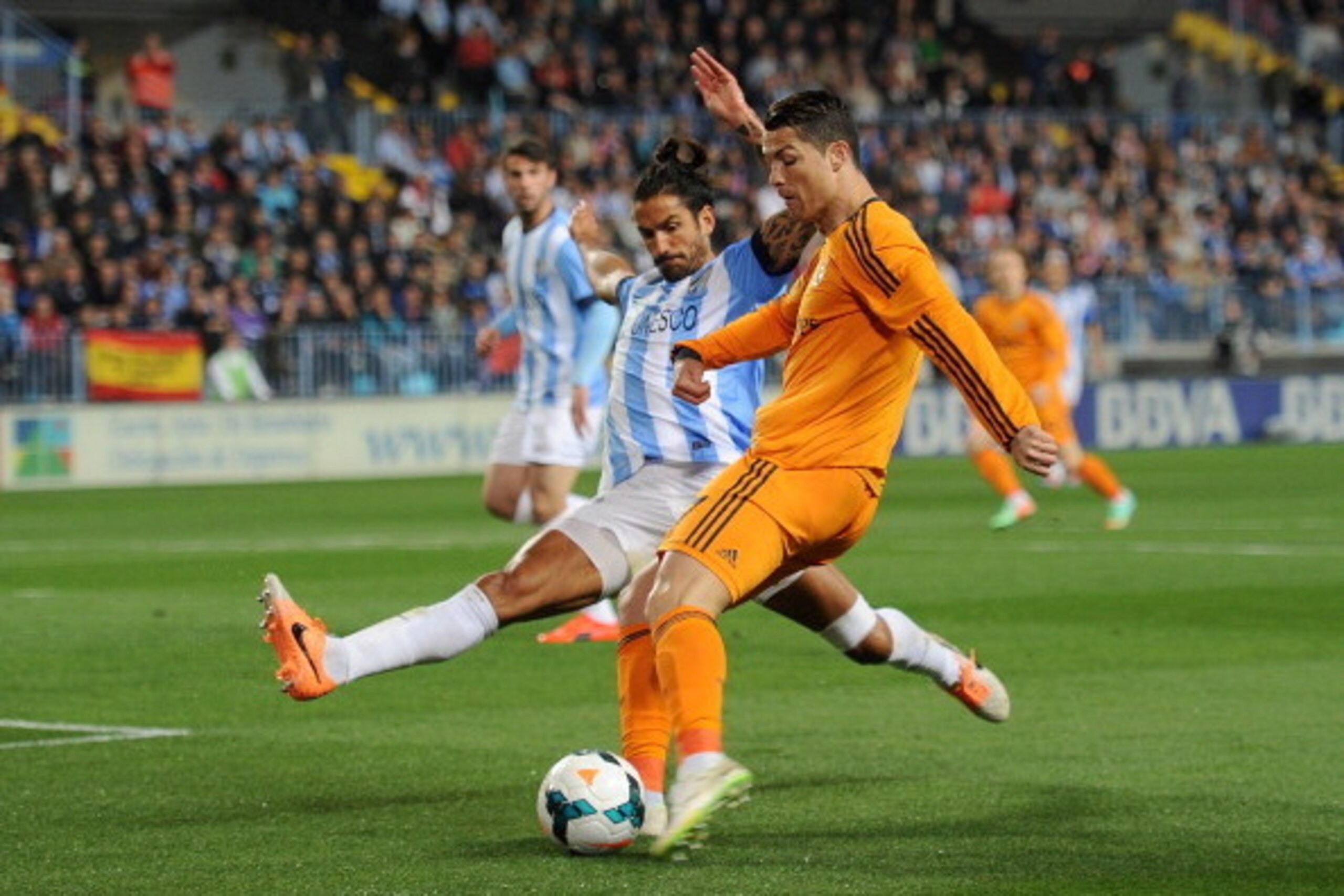 MALAGA, SPAIN - MARCH 15:  Cristiano Ronaldo (R) of Real Madrid is tackled by Marcos Angeleri of Malaga during the La Liga match between Malaga and Real Madrid at La Rosaleda Stadium on March 15, 2014 in Malaga, Spain.  (Photo by Denis Doyle/Getty Images)