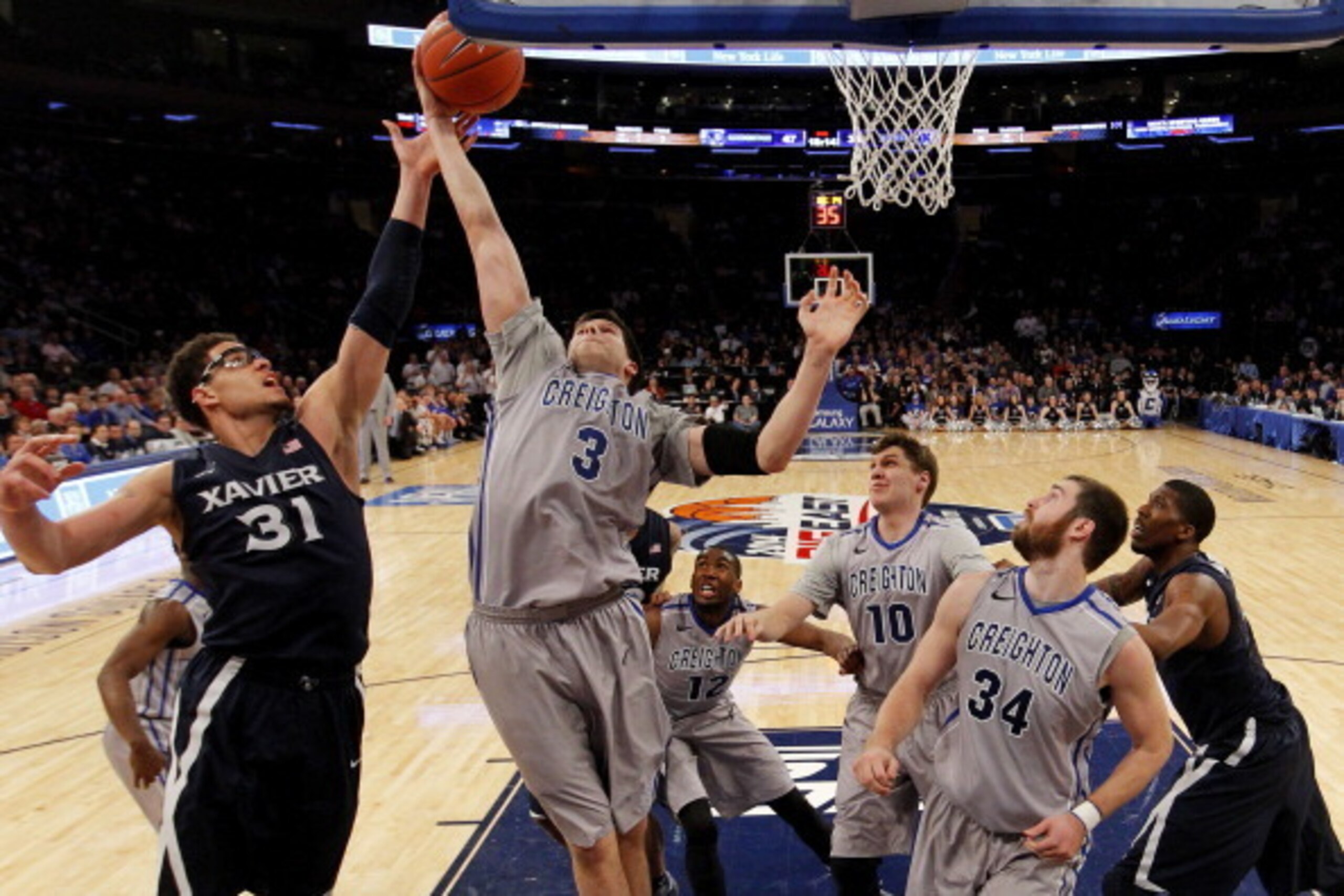 NEW YORK, NY - MARCH 14:  Doug McDermott #3 of the Creighton Bluejays rebounds over Isaiah Philmore #31 of the Xavier Musketeers in the second half during the Semifinals of the 2014 Men's Big East Basketball Tournament at Madison Square Garden on March 14