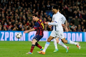 BARCELONA, SPAIN - MARCH 12:  Lionel Messi of Barcelona scores the opening goal as Joleon Lescott of Manchester City closes in during the UEFA Champions League Round of 16, second leg match between FC Barcelona and Manchester City  at Camp Nou on March 12
