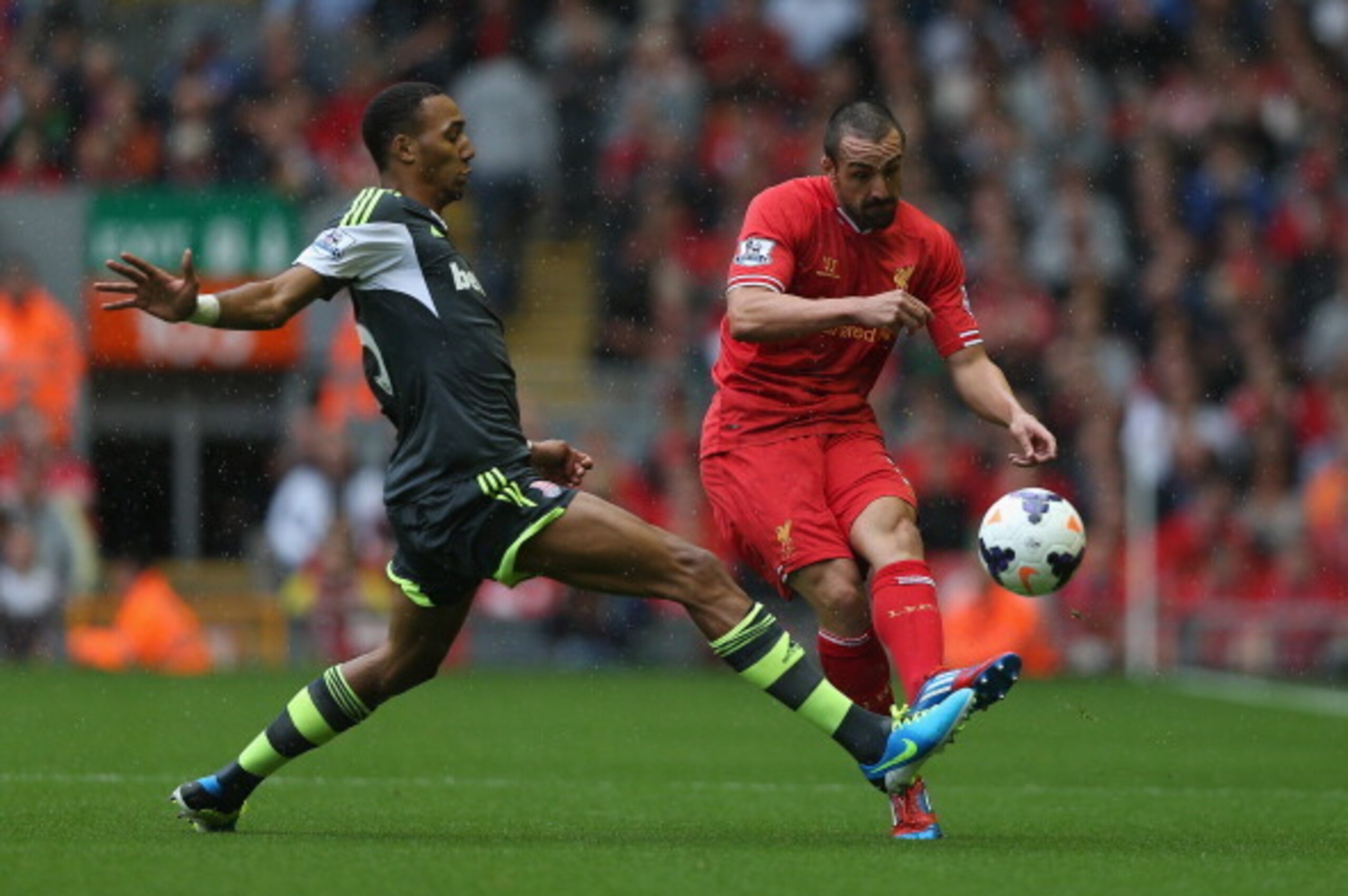 LIVERPOOL, ENGLAND - AUGUST 17: Jose Enrique of Liverpool passes the ball past Steven N'Zonzi of Stoke City during the Barclays Premier League match between Liverpool and Stoke City at Anfield on August 17, 2013 in Liverpool, England. (Photo by Clive Brun