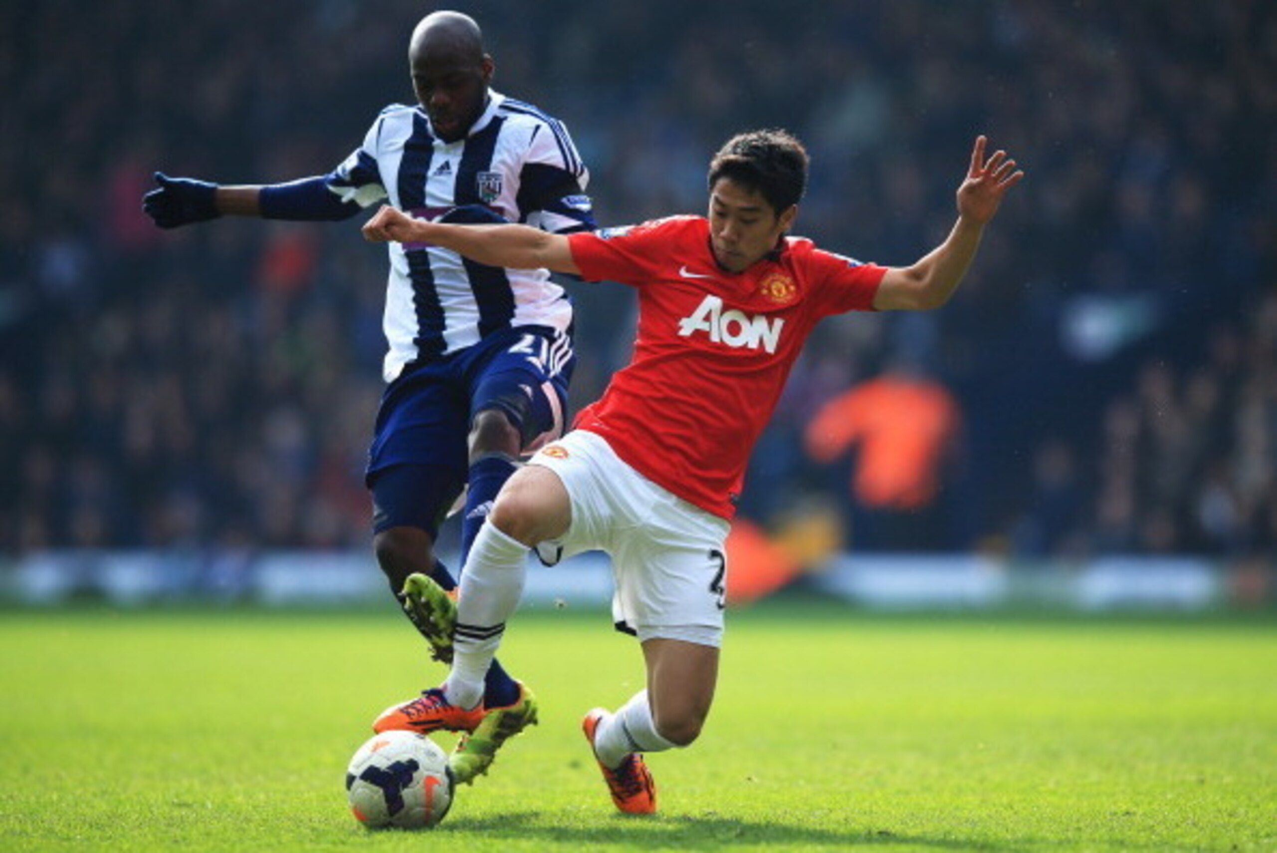 WEST BROMWICH, ENGLAND - MARCH 08:  Shinji Kagawa of Manchester United tackles Youssuf Mulumbu of West Bromwich Albion during the Barclays Premier League match between West Bromwich Albion and Manchester United at The Hawthorns on March 8, 2014 in West Br