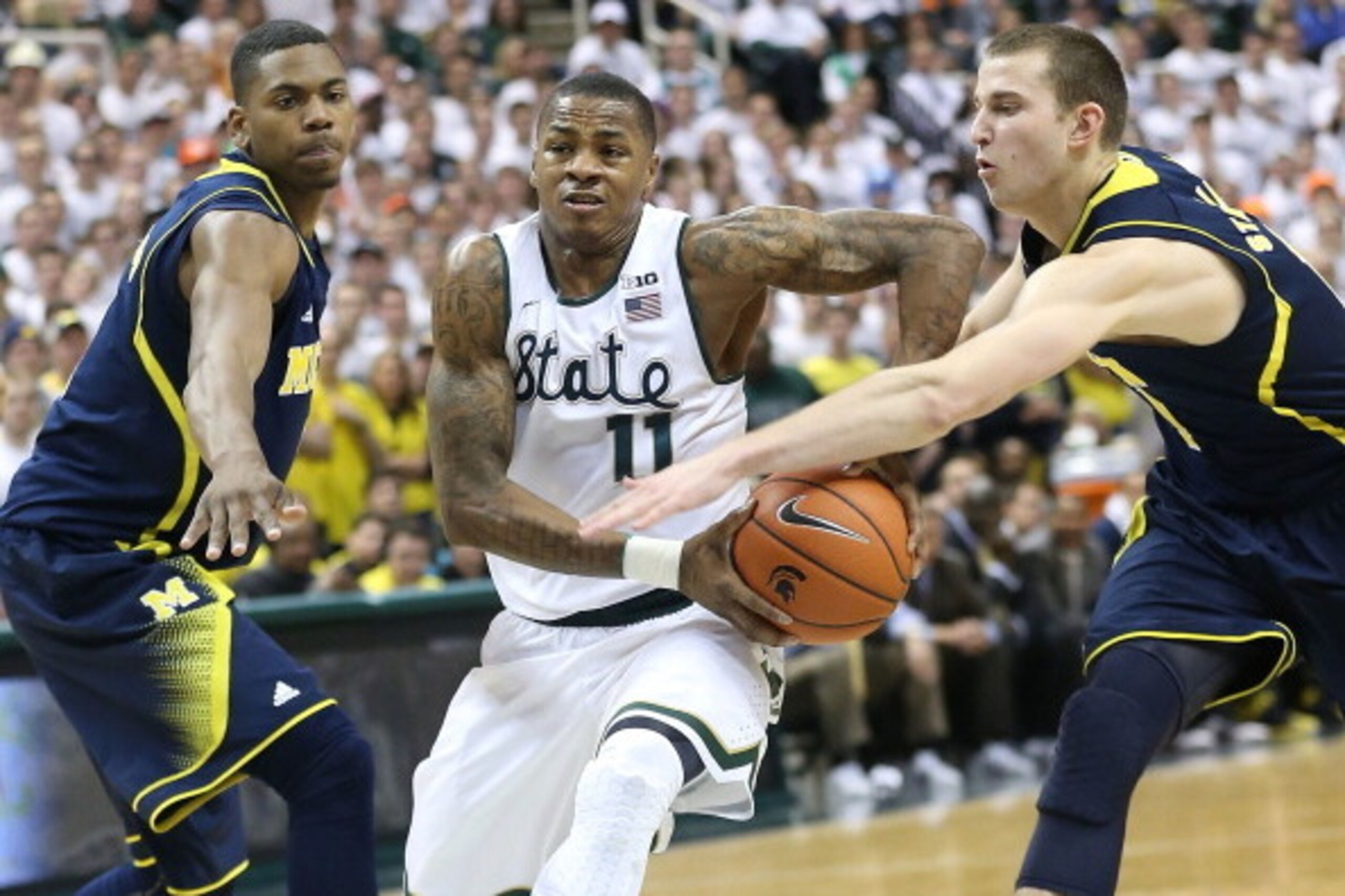 EAST LANSING, MI - JANUARY 25: Keith Appling #11 of the Michigan State Spartans drives the ball to the basket as Glenn Robinson III #1 and Nik Stauskas #11 of the University of Michigan defend during the second half of the game at Breslin Center on Januar EAST LANSING, MI - JANUARY 25: Keith Appling #11 of the Michigan State Spartans drives the ball to the basket as Glenn Robinson III #1 and Nik Stauskas #11 of the University of Michigan defend during the second half of the game at Breslin Center on Januar
