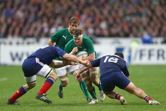 PARIS, FRANCE - MARCH 15:  Jamie Heaslip of Ireland is tackled by Rabah Slimani (R) and Wenceslas Lauret (L) of France during the RBS Six Nations match between France and Ireland at Stade de France on March 15, 2014 in Paris, France.  (Photo by Paul Gilha