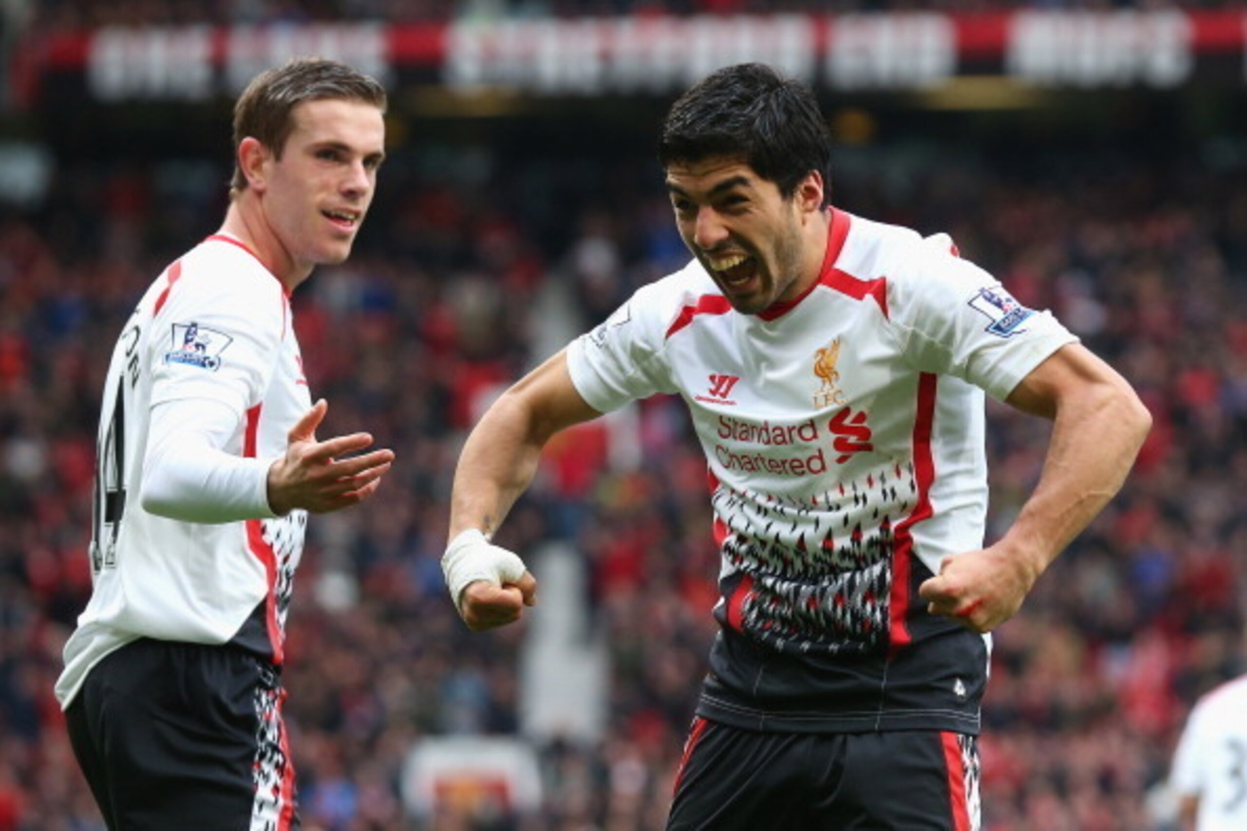 MANCHESTER, ENGLAND - MARCH 16:  Luis Suarez of Liverpool celebrates scoring his team's third goal with team-mate Jordan Henderson (L) during the Barclays Premier League match between Manchester United and Liverpool at Old Trafford on March 16, 2014 in Ma