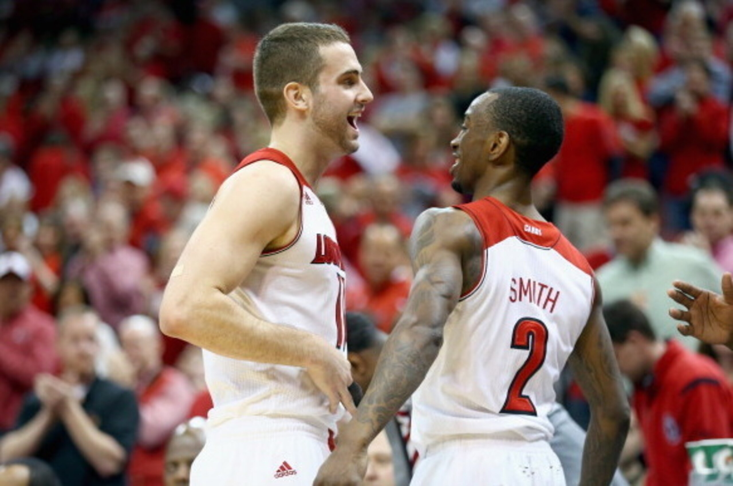 LOUISVILLE, KY - MARCH 08: Luke Hancock #11 and Russ Smith #2 of the Louisville Cardinals celebrates in the final minutes of the game against the Connecticut Huskies at KFC YUM! Center on March 8, 2014 in Louisville, Kentucky.  It was senior day and it wa