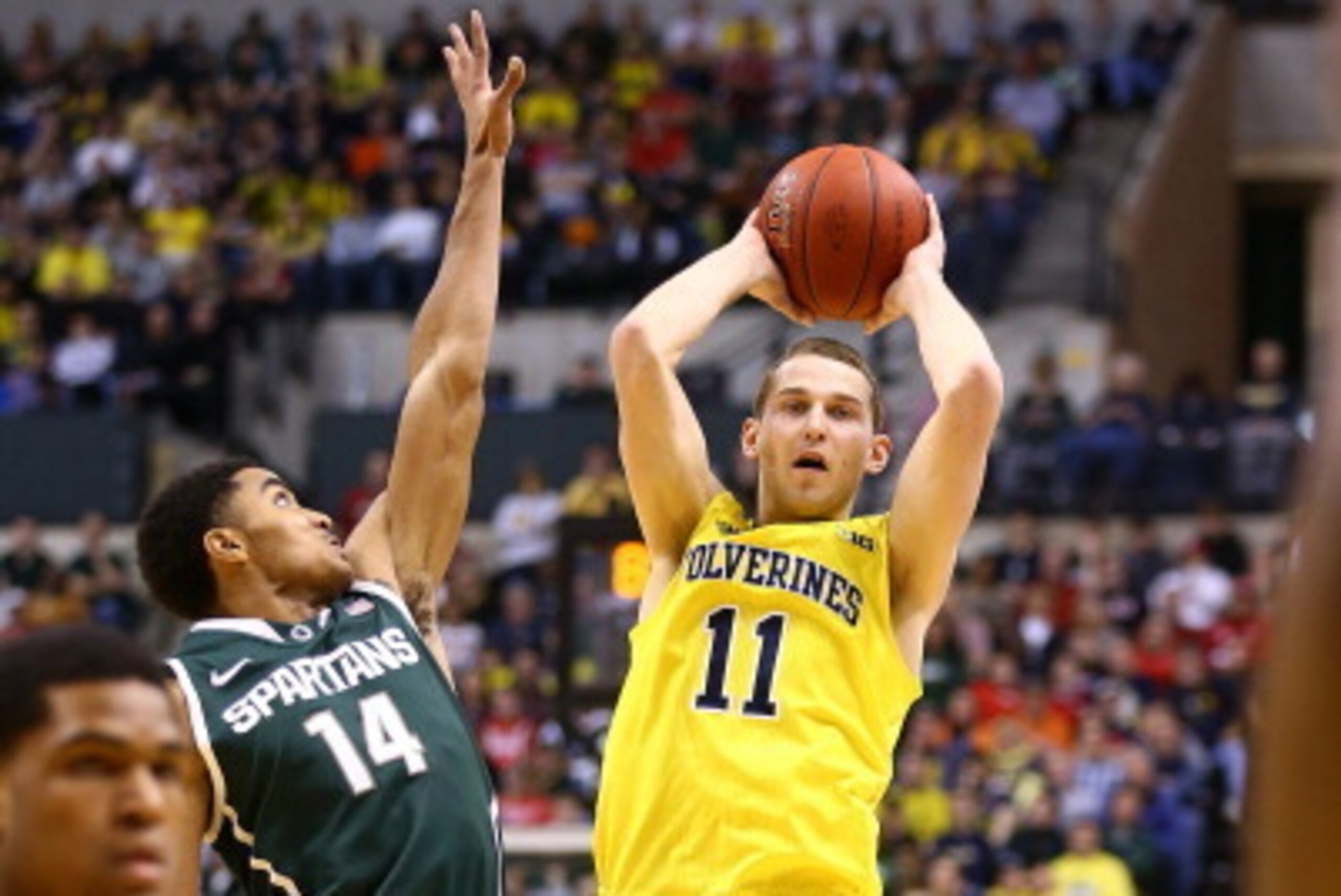 INDIANAPOLIS, IN - MARCH 16: Nik Stauskas #11 of the Michigan Wolverines looks to pass as Gary Harris #14 of the Michigan State Spartans defends during the 2014 Big Ten Men's Championship at Bankers Life Fieldhouse on March 16, 2014 in Indianapolis, India