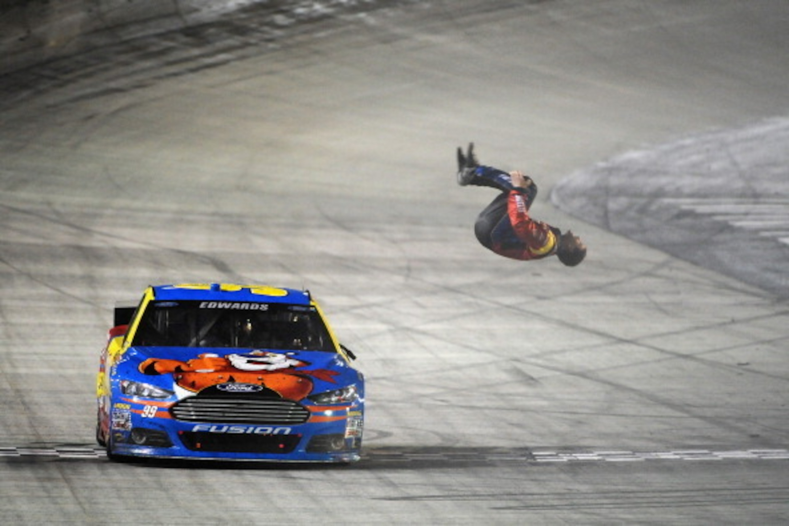 BRISTOL, TN - MARCH 16:  Carl Edwards, driver of the #99 Kellogg's/Frosted Flakes Ford, celebrates with a backflip after winning the NASCAR Sprint Cup Series Food City 500 at Bristol Motor Speedway on March 16, 2014 in Bristol, Tennessee.  (Photo by Jonat