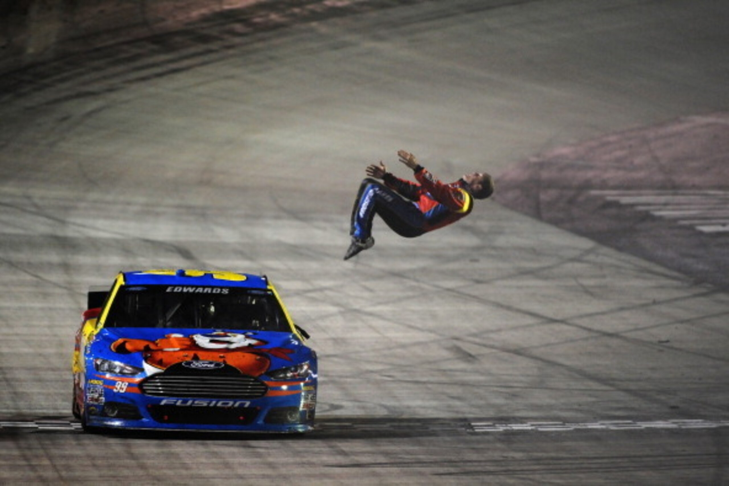 BRISTOL, TN - MARCH 16:  Carl Edwards, driver of the #99 Kellogg's/Frosted Flakes Ford, celebrates with a backflip after winning the NASCAR Sprint Cup Series Food City 500 at Bristol Motor Speedway on March 16, 2014 in Bristol, Tennessee.  (Photo by Jonat