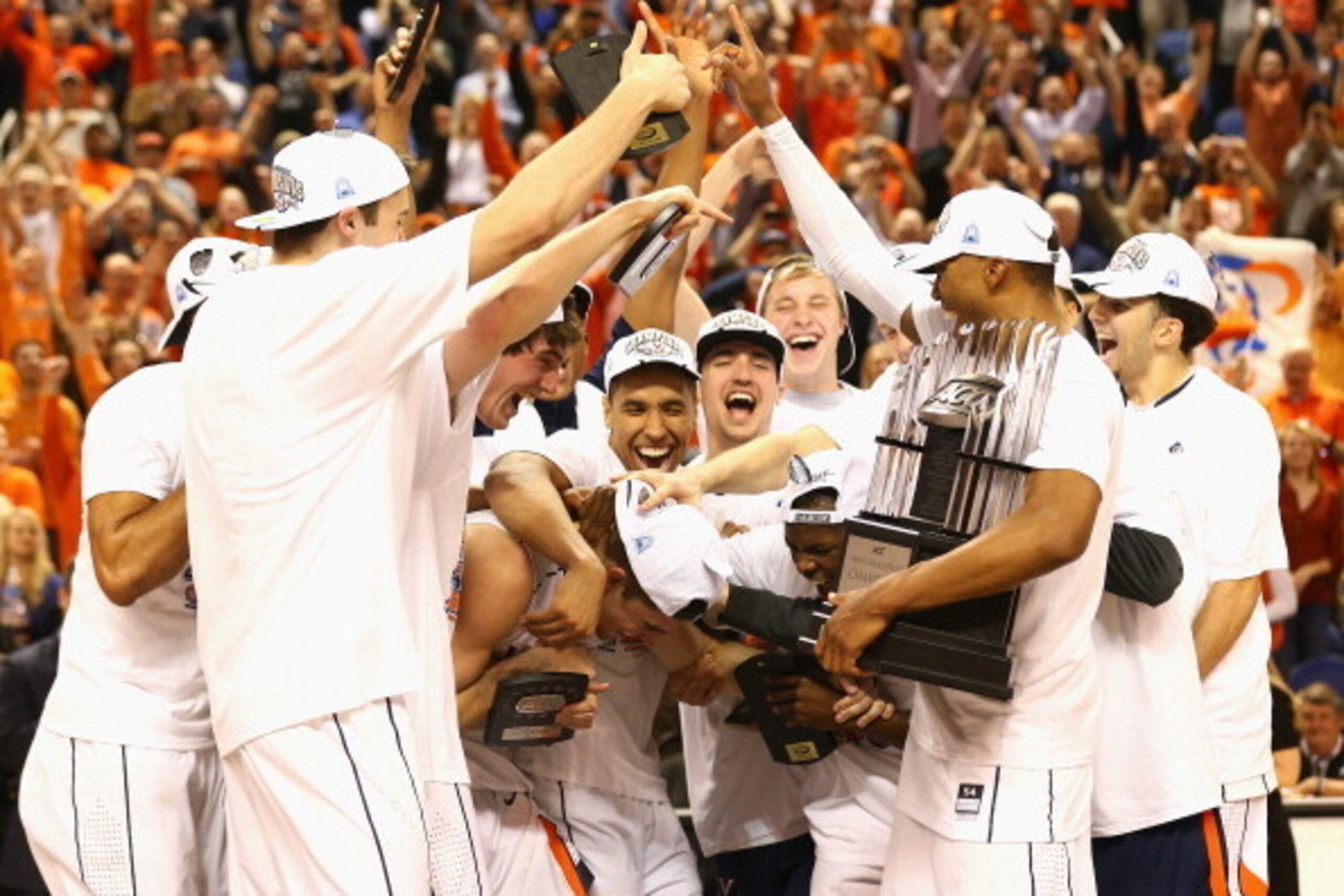 GREENSBORO, NC - MARCH 16:  Teammates gather around Joe Harris #12 of the Virginia Cavaliers after he won the MVP against the Duke Blue Devils during the championship game of the 2014 Men's ACC Basketball Tournament at Greensboro Coliseum on March 16, 201