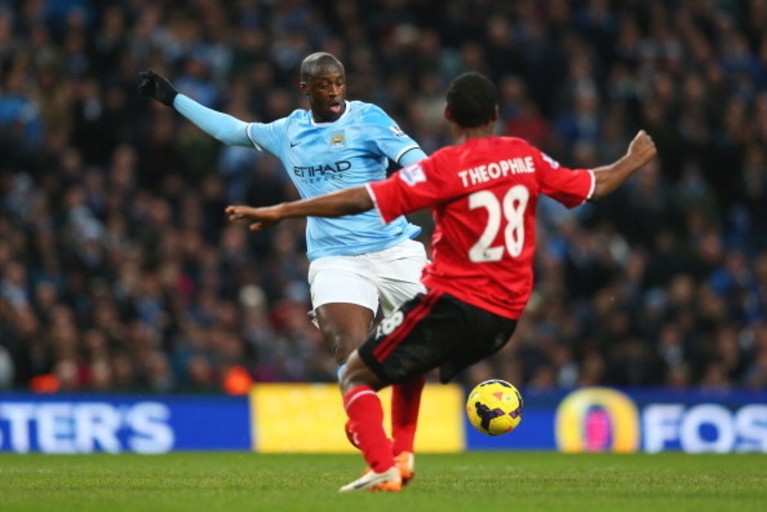 MANCHESTER, ENGLAND - JANUARY 18:  Yaya Toure of Manchester City shoost past Kevin Theophile Catherine of Cardiff to score his team's third goal during the Barclays Premier League match between Manchester City and Cardiff City at the Etihad Stadium on Jan