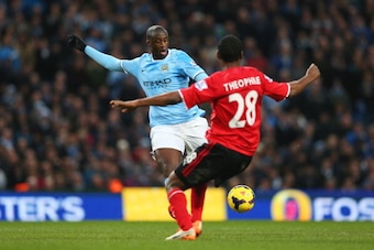 MANCHESTER, ENGLAND - JANUARY 18: Yaya Toure of Manchester City shoost past Kevin Theophile Catherine of Cardiff to score his team's third goal during the Barclays Premier League match between Manchester City and Cardiff City at the Etihad Stadium on Jan MANCHESTER, ENGLAND - JANUARY 18: Yaya Toure of Manchester City shoost past Kevin Theophile Catherine of Cardiff to score his team's third goal during the Barclays Premier League match between Manchester City and Cardiff City at the Etihad Stadium on Jan