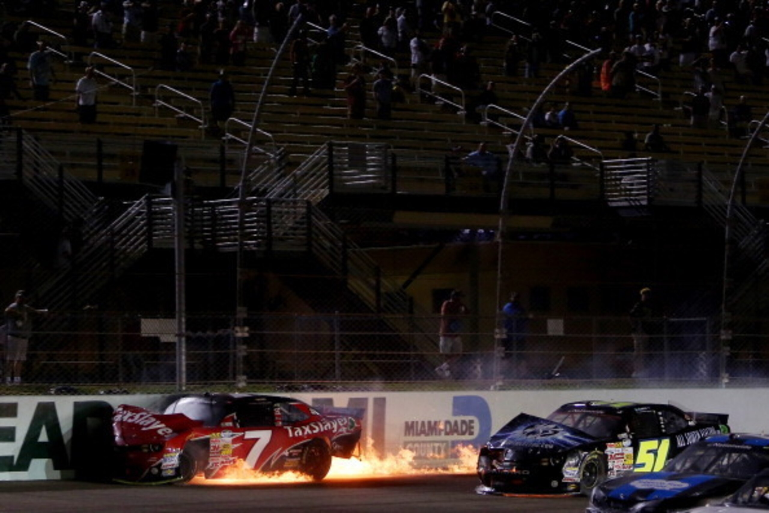 HOMESTEAD, FL - NOVEMBER 16:  Regan Smith, driver of the #7 TaxSlayer.com Chevrolet, and Jeremy Clements, driver of the #51 AllSouthElectric.com Chevrolet, are involved in an incident during the NASCAR Nationwide Series Ford EcoBoost 300 at Homestead-Miam
