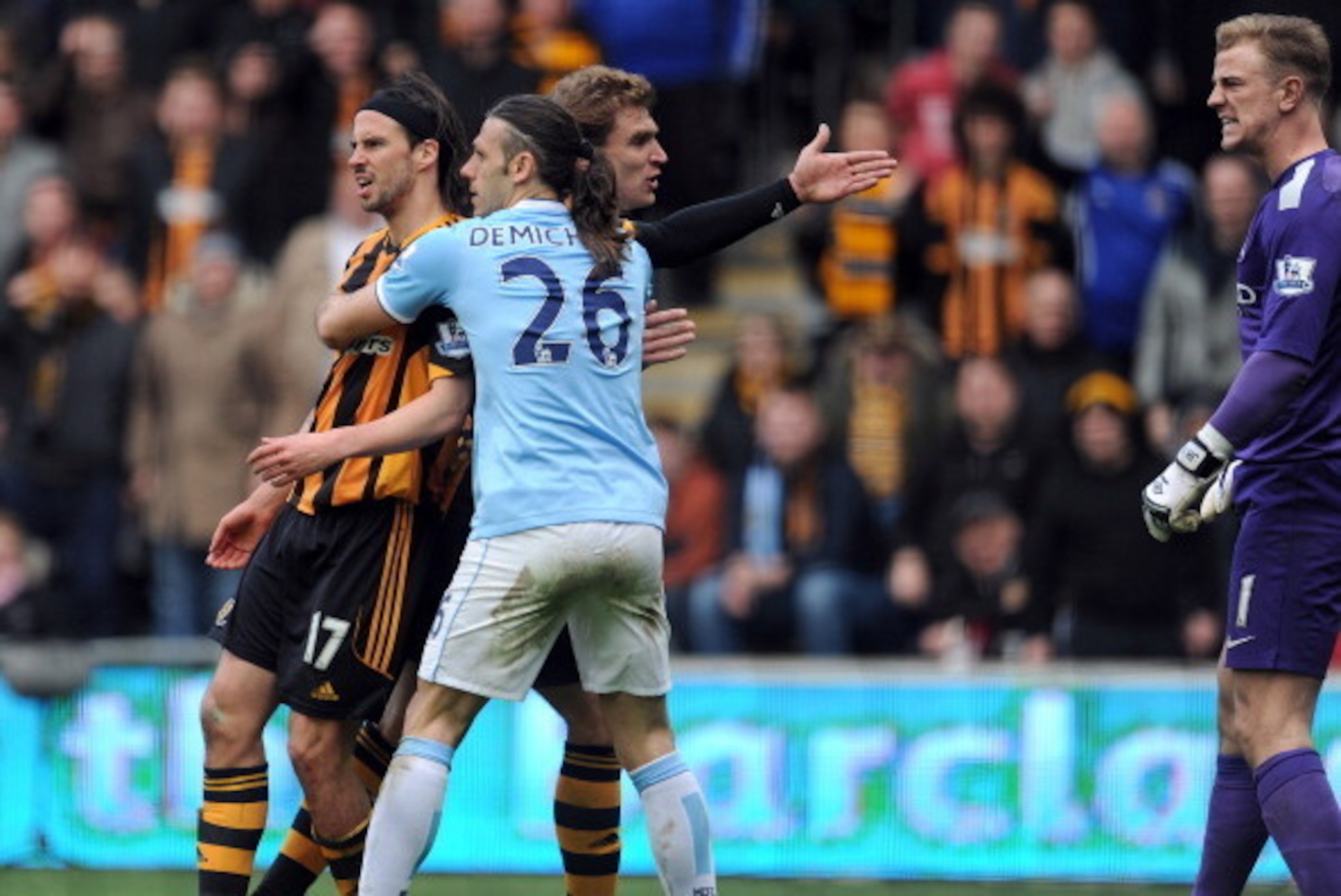 HULL, ENGLAND - MARCH 15:  George Boyd (L) of Hull City is held back by Martin Demichelis (C) of Manchester City after a clash with Joe Hart (R) during the Barclays Premier League match between Hull City and Manchester City at the KC Stadium on March 15, 