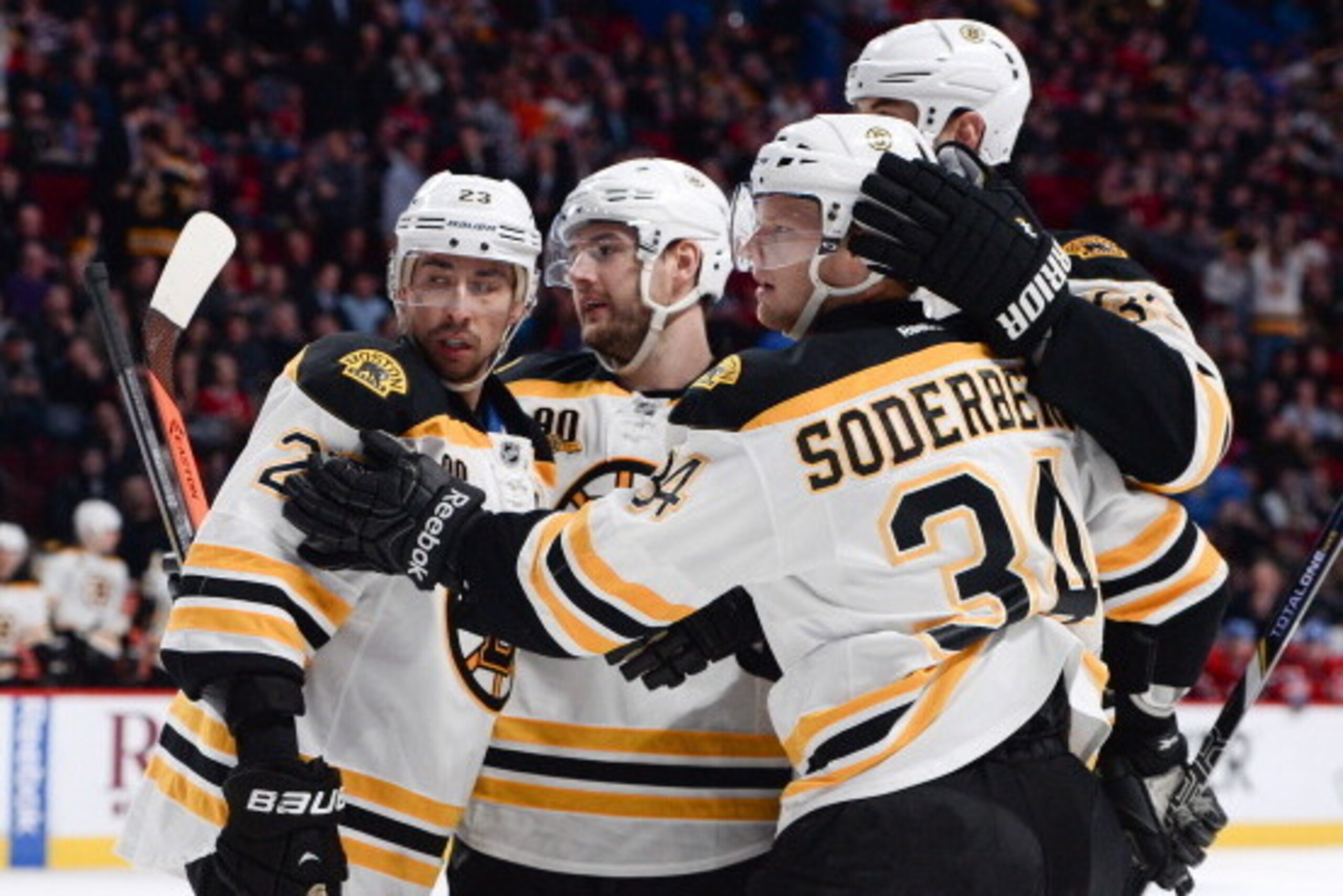 MONTREAL, QC - MARCH 12: Carl Soderberg #34 of the Boston Bruins celebrates after scoring a goal against the Montreal Canadiens, with teammates Chris Kelly #23, Andrej Meszaros #41and Zdeno Chara #33 during the NHL game on March 12, 2014 at the Bell Centr