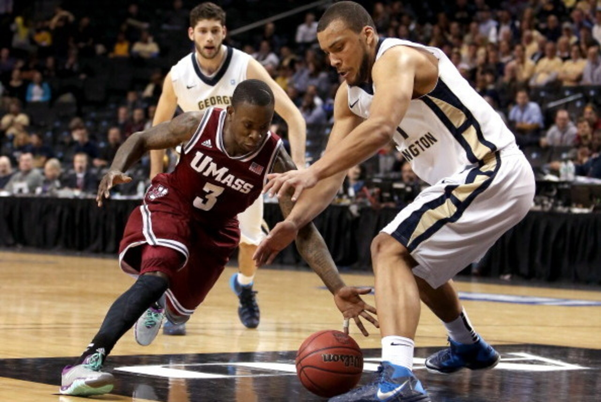 NEW YORK, NY - MARCH 14: Chaz Williams #3 of the Massachusetts Minutemen and Kevin Larsen #21 of the George Washington Colonials go for a loose ball in the second half during the Quarterfinals of the 2014 Atlantic 10 Men's Basketball Tournament at Barclay