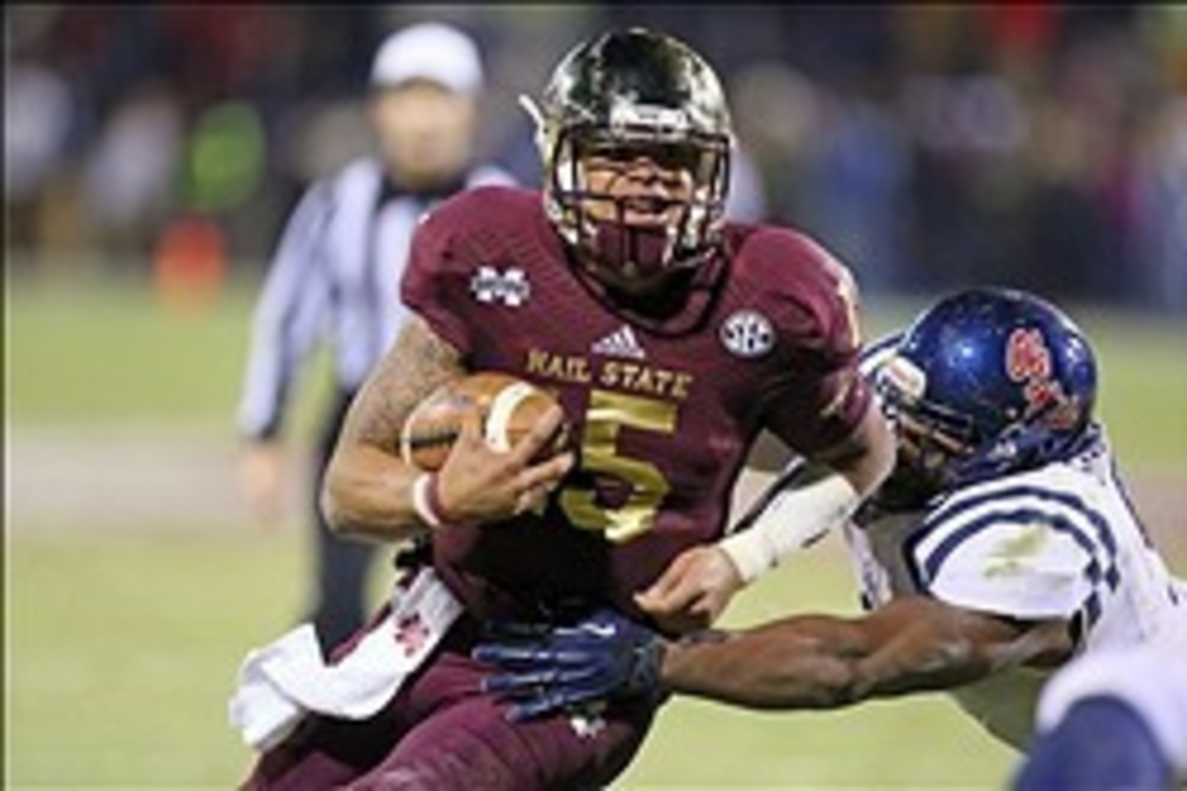 Nov 28, 2013; Starkville, MS, USA; Mississippi State Bulldogs quarterback Dak Prescott (15) advances the ball during the game against the Mississippi Rebels at Davis Wade Stadium. Mississippi State Bulldogs defeat the Mississippi Rebels with a score of 17