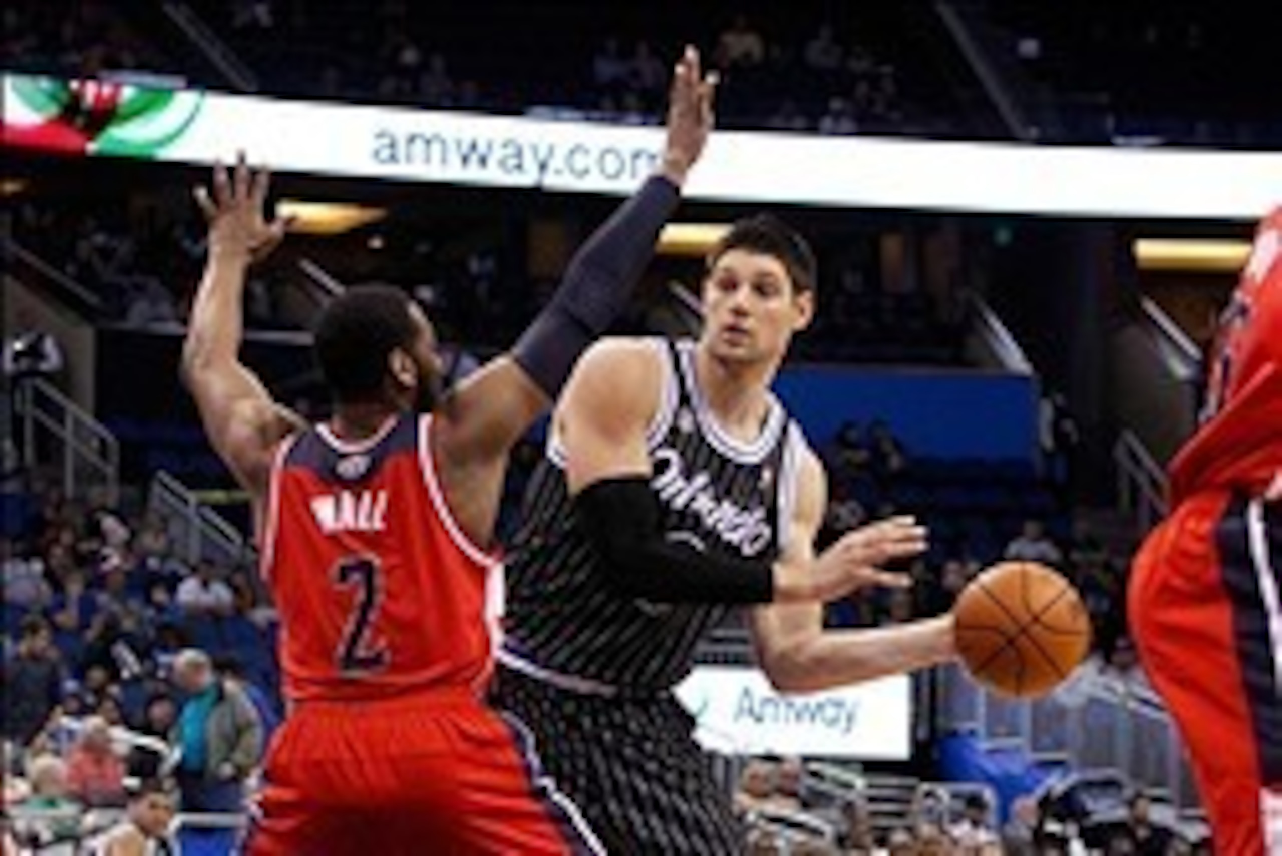 Mar 14, 2014; Orlando, FL, USA; Orlando Magic center Nikola Vucevic (9) passes the ball as Washington Wizards guard John Wall (2) defends during the second half at Amway Center. Washington Wizards defeated the Orlando Magic 105-101. Mandatory Credit: Kim 