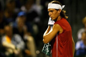 MIAMI - MARCH 28:  Rafael Nadal of Spain wipes sweat off his face during his match against Roger Federer of Switzerland on March 28, 2004 during Nasdaq 100 Open at the Crandon Park Tennis Center on Key Biscayne in Miami, Florida.  (Photo by Ezra Shaw/Gett
