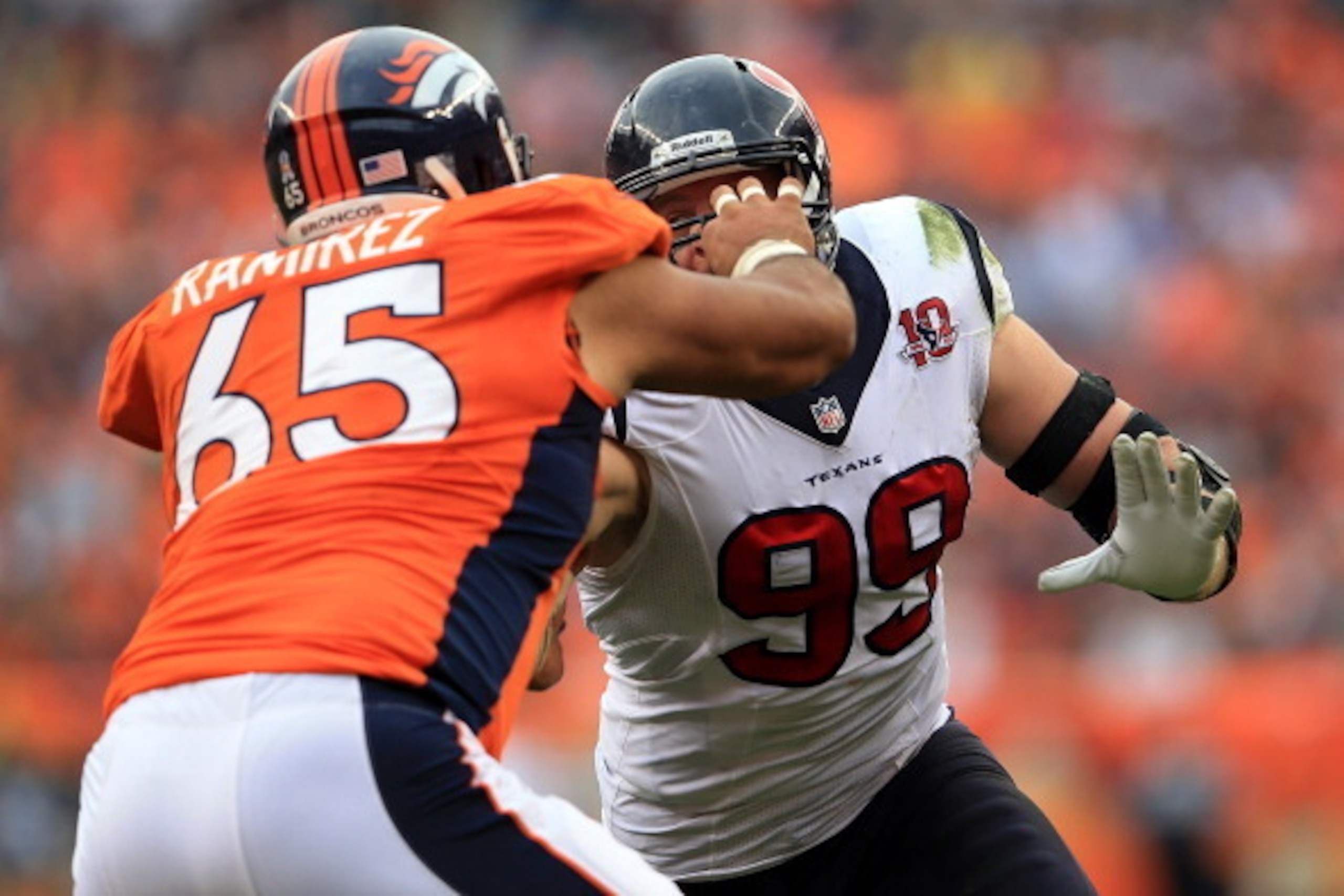 DENVER, CO - SEPTEMBER 23:  Defensive end J.J. Watt #99 of the Houston Texans rushes the line of scrimage against guard Manny Ramirez #65 of the Denver Broncos at Sports Authority Field at Mile High on September 23, 2012 in Denver, Colorado. The Texans de