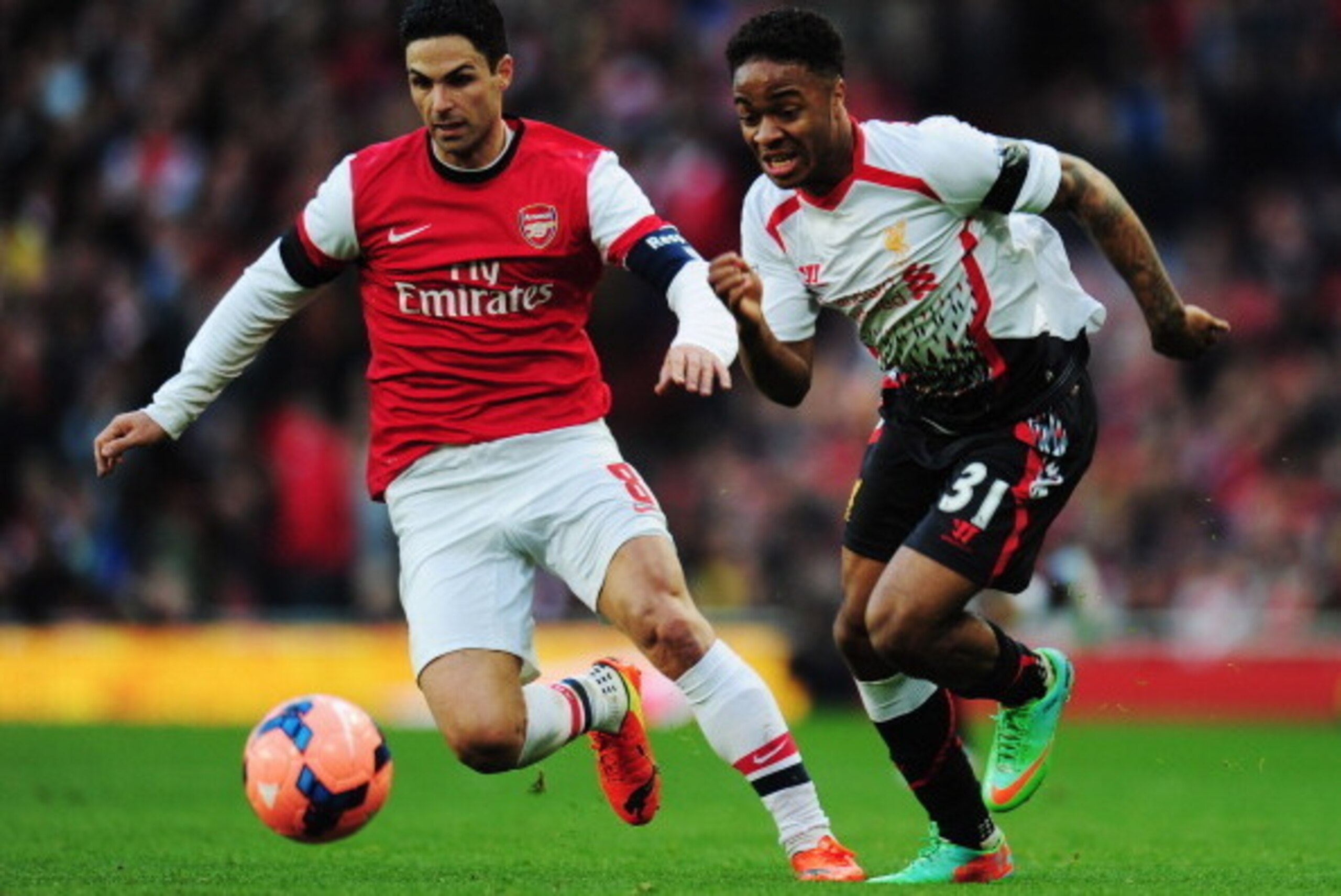 LONDON, ENGLAND - FEBRUARY 16:  Raheem Sterling (R) of Liverpool holds off the challenge of Mikel Arteta (L) of Arsenal during the FA Cup Fifth Round match between Arsenal and Liverpool at the Emirates Stadium on February 16, 2014 in London, England.  (Ph