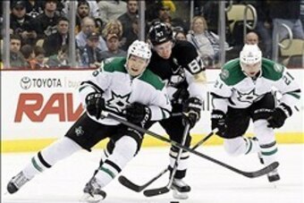 Mar 18, 2014; Pittsburgh, PA, USA; Pittsburgh Penguins center Sidney Crosby (87) chases the puck as Dallas Stars left wing Ryan Garbutt (16) and left wing Antoine Roussel (21) defend during the second period at the CONSOL Energy Center. Mandatory Credit: 