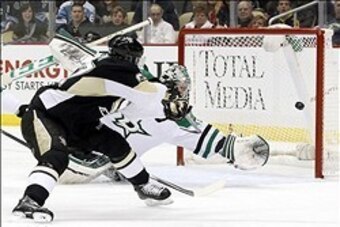 Mar 18, 2014; Pittsburgh, PA, USA; Pittsburgh Penguins center Sidney Crosby (left) scores on a back-handed shot past Dallas Stars goalie Kari Lehtonen (32) during the first period at the CONSOL Energy Center. Mandatory Credit: Charles LeClaire-USA TODAY S