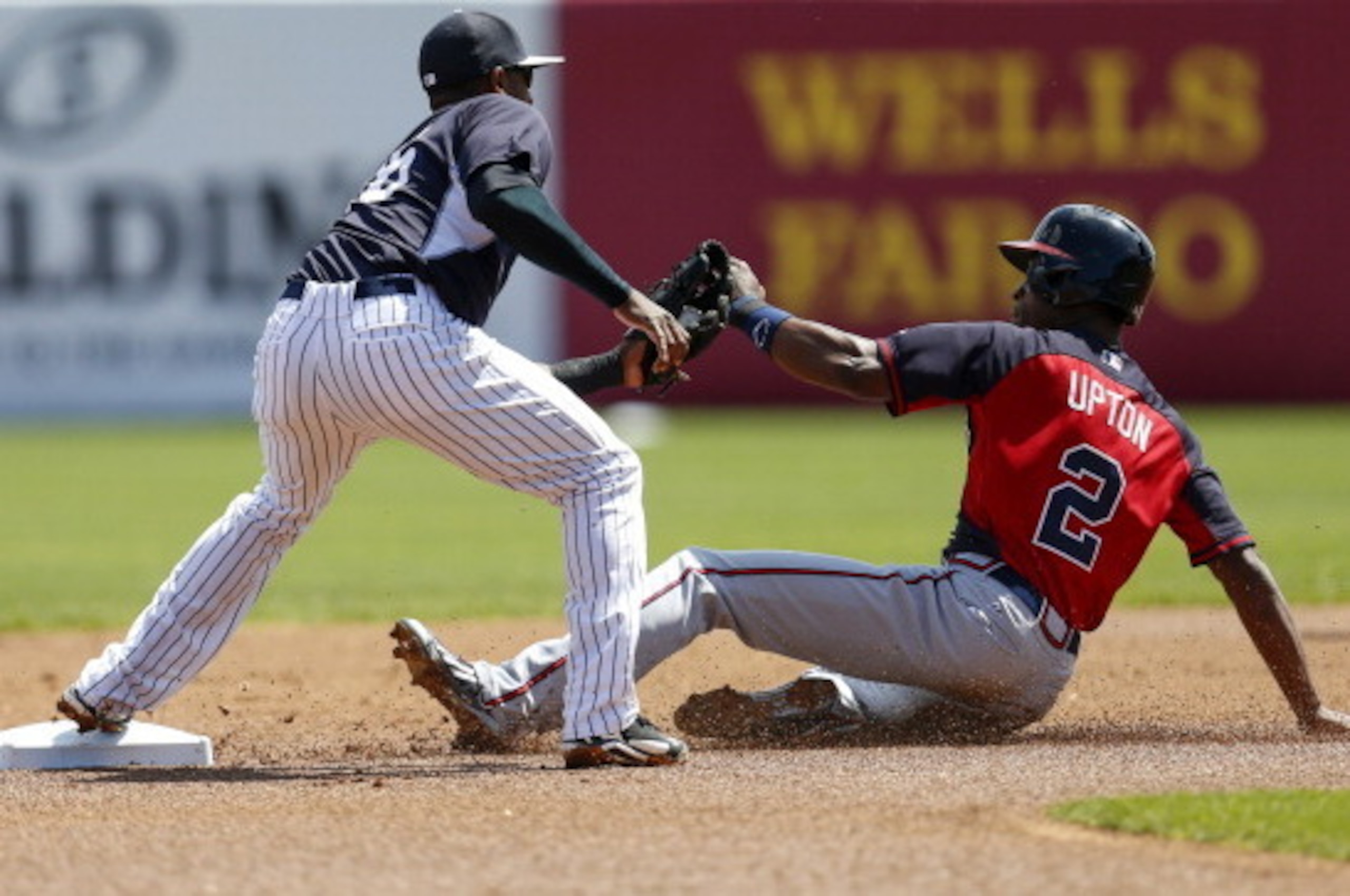 TAMPA, FL - MARCH 16:  B.J. Upton #2 of the Atlanta Braves slides in under the tag of second baseman Eduardo Nunez #26 of the New York Yankees for a steal  during a spring training game at George M. Steinbrenner Field on March 16, 2014 in Tampa, Florida. 